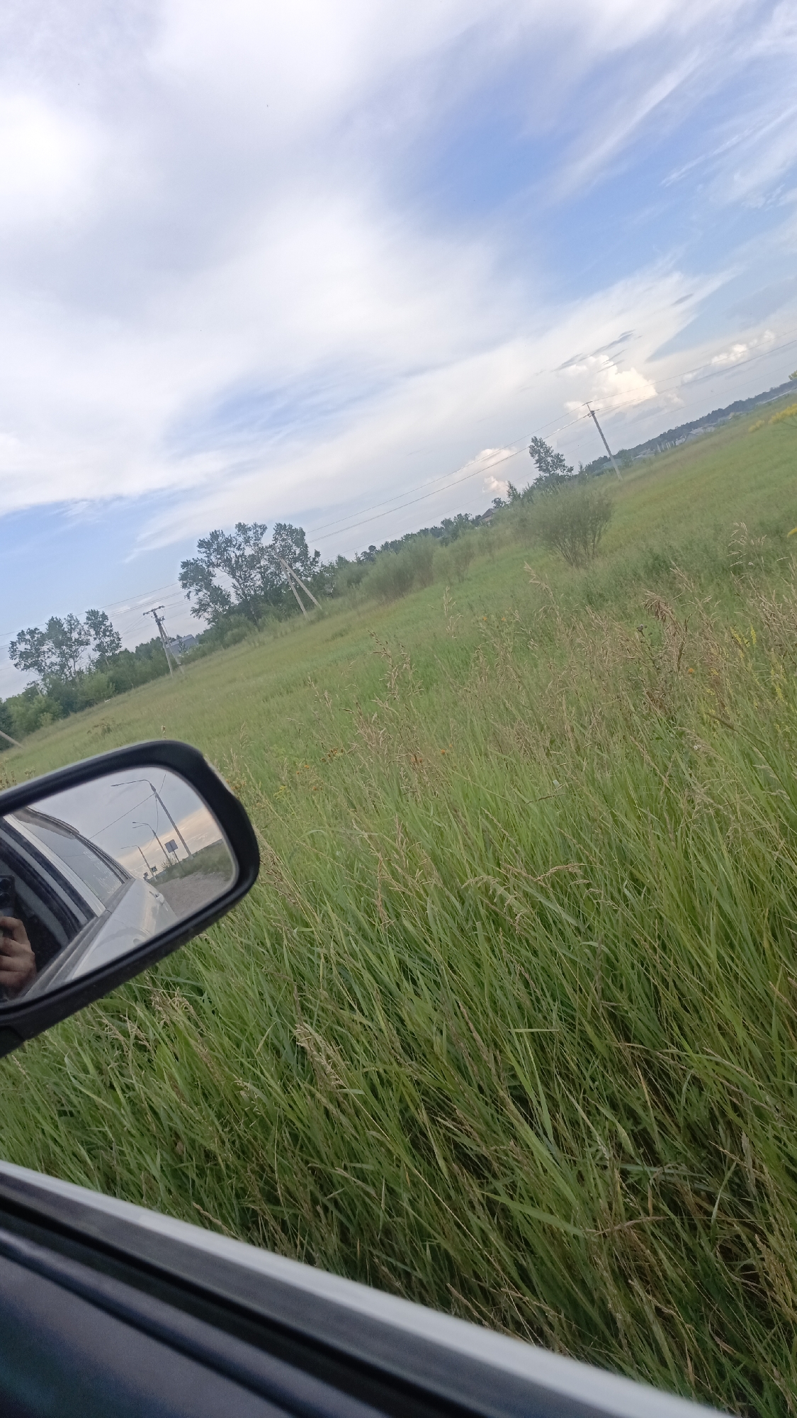 Rolling through rural Angarsk, roadside fields and mirror reflections