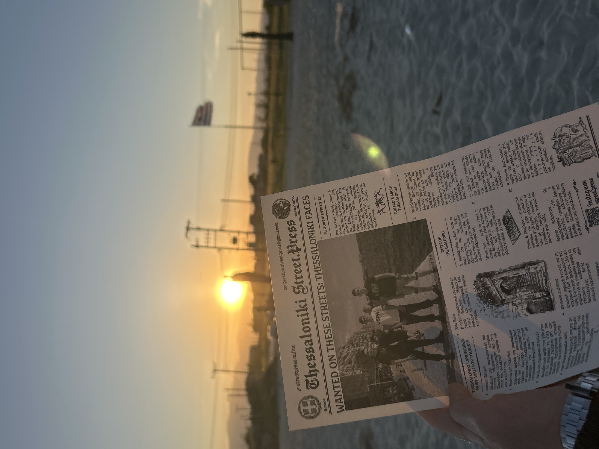 Young men photograph sunset at Greek beach gathering