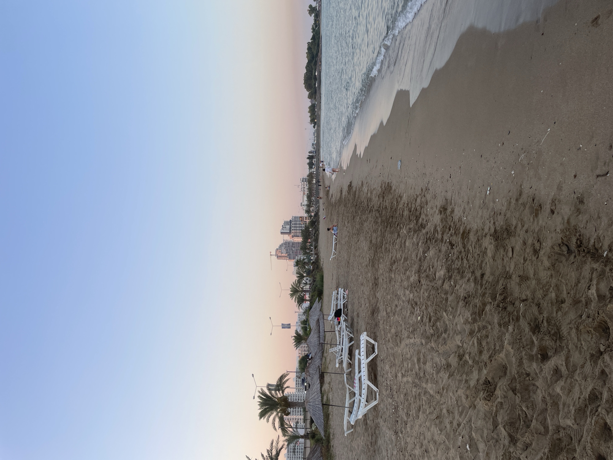 Trikomo beach at dusk, lounge chairs and calm surf