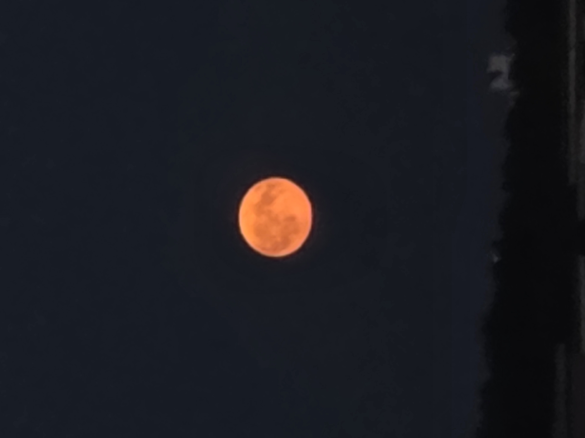 Big orange moon rises over Minsk on a July night