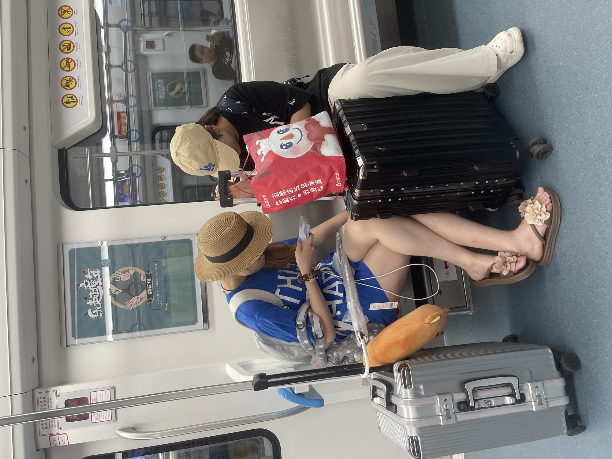 Quiet subway ride, phones out, straw hat in frame