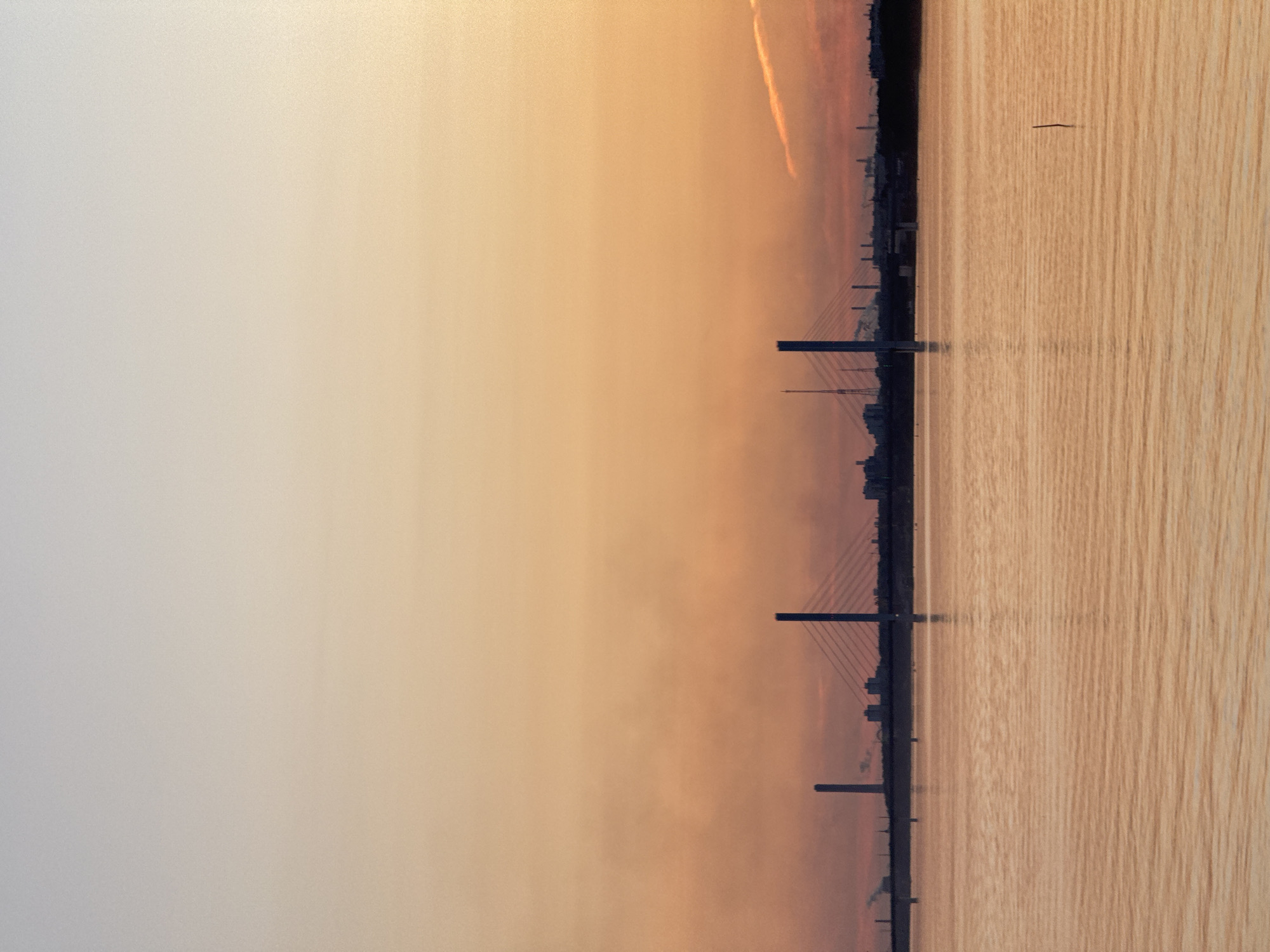 Golden hour over a Russian river, bridge and boat in view