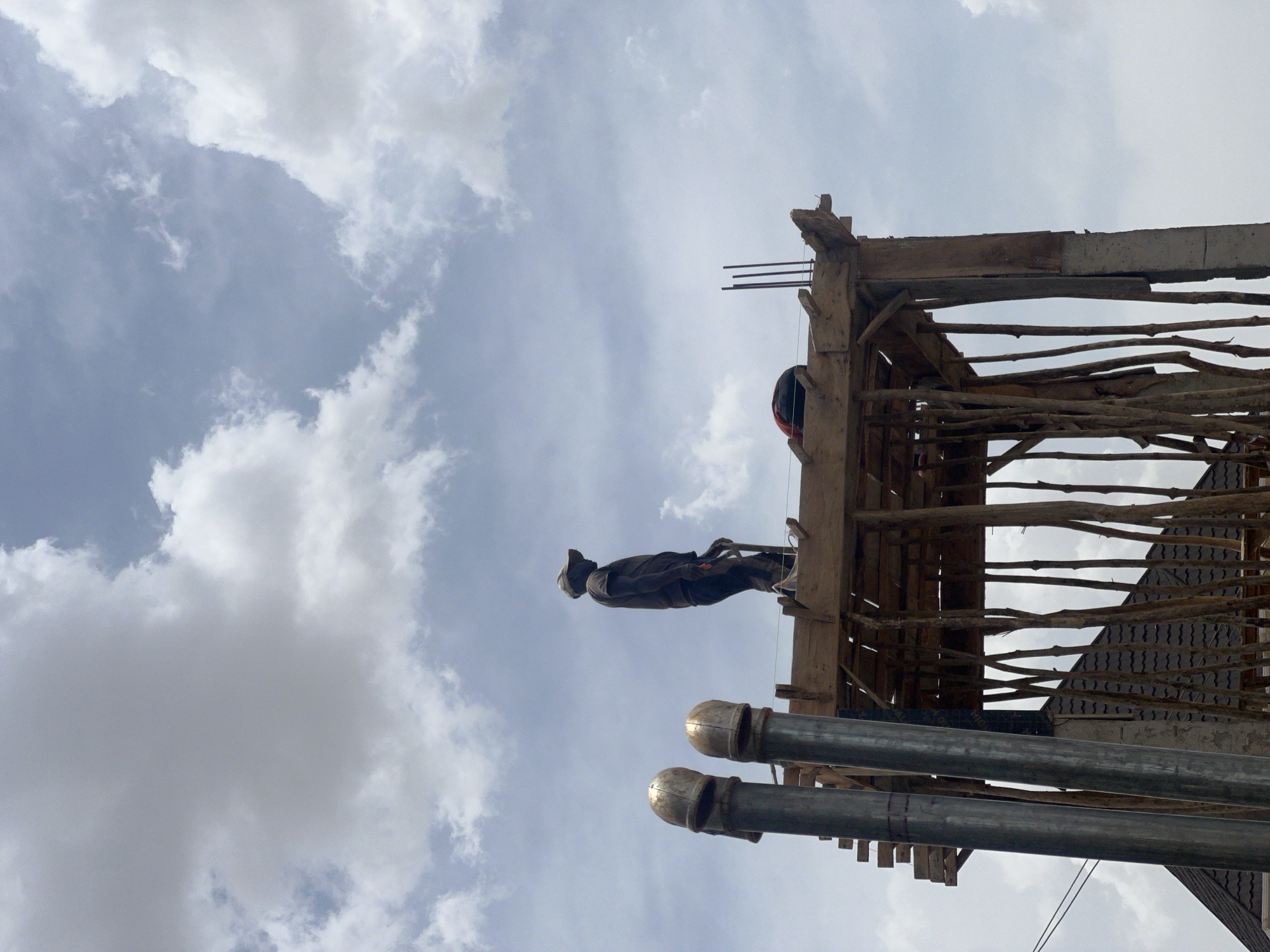 Construction workers build wooden structures in Jos, Nigeria