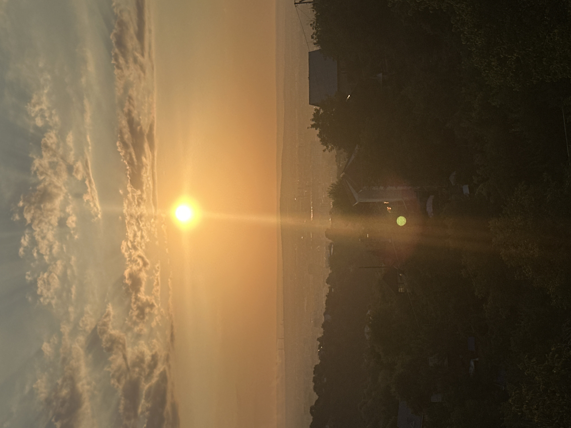 Golden sunset over Almaty, framed from a high-rise balcony