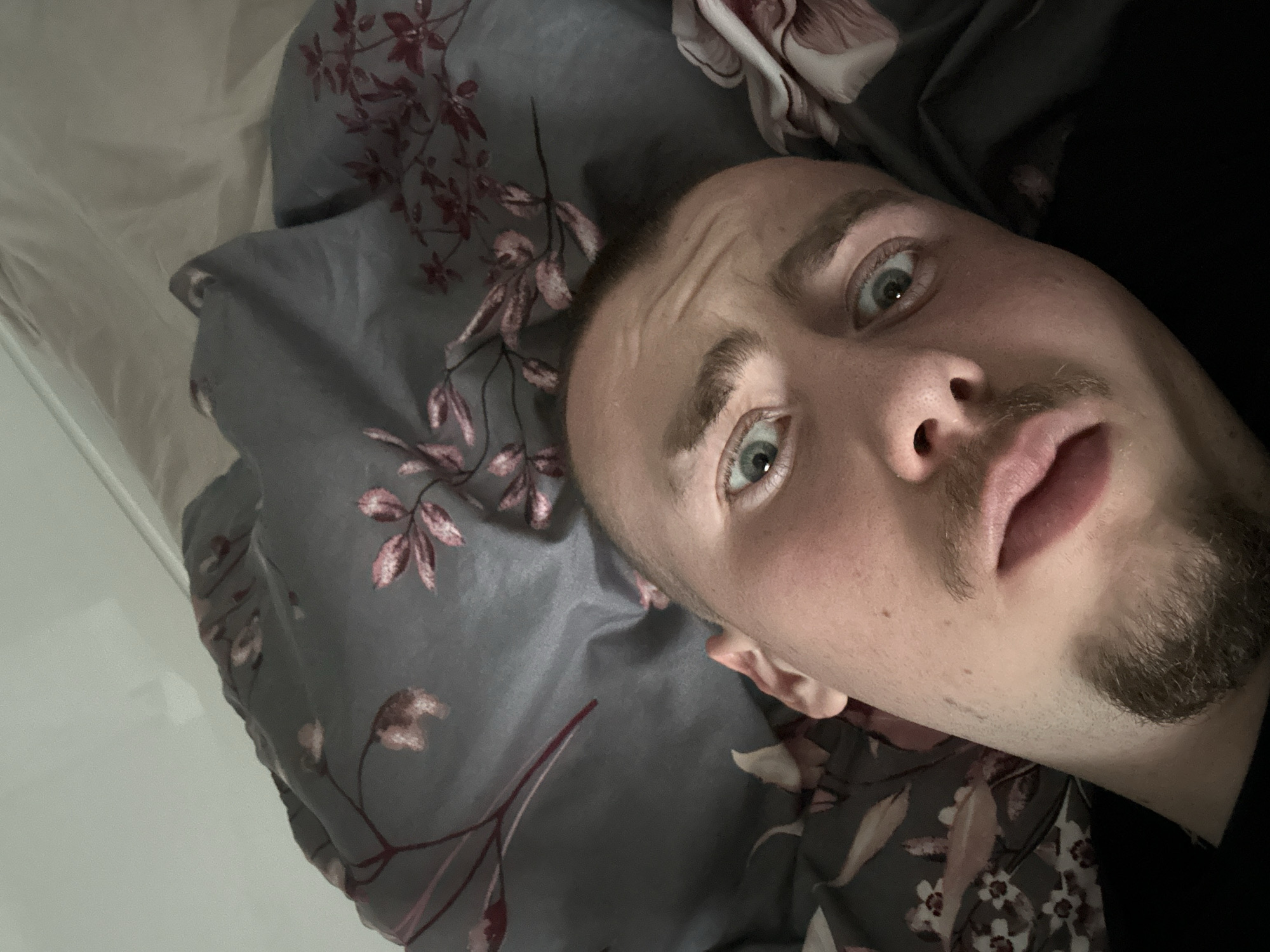 Man takes selfie on floral bedding in Sofia