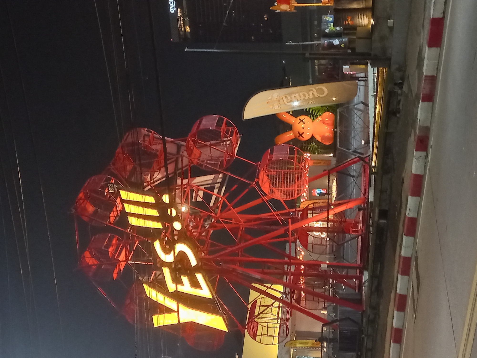 Pattaya nighttime attractions captured with illuminated Ferris wheel, decorative lighting