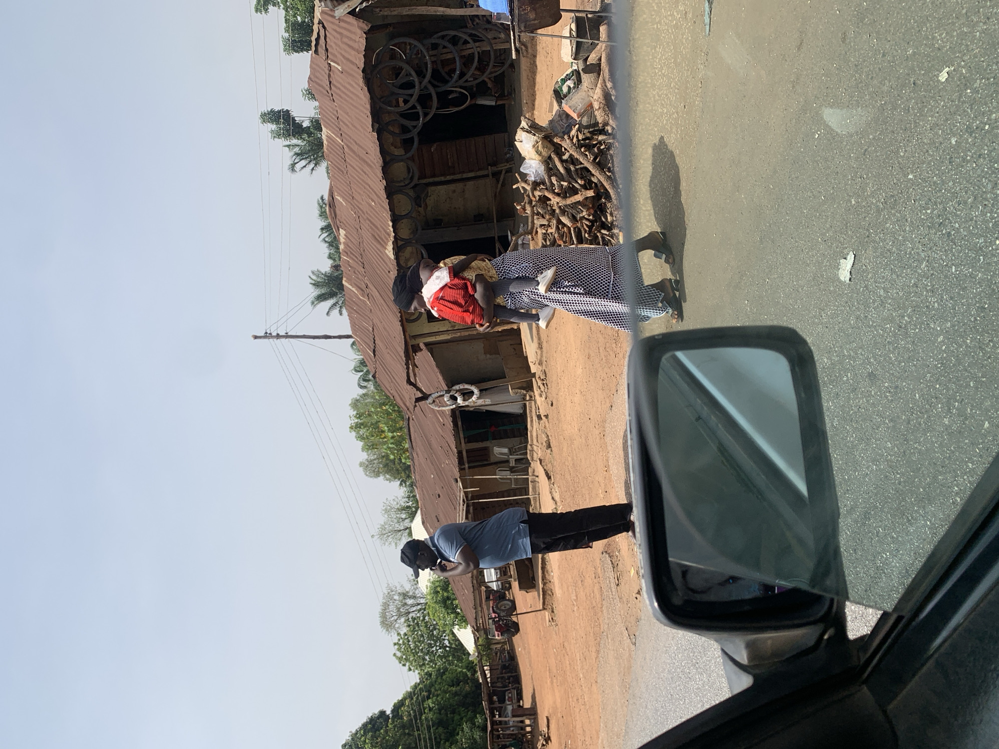 Woman with child spotted outside shop in Karshi, Nigeria