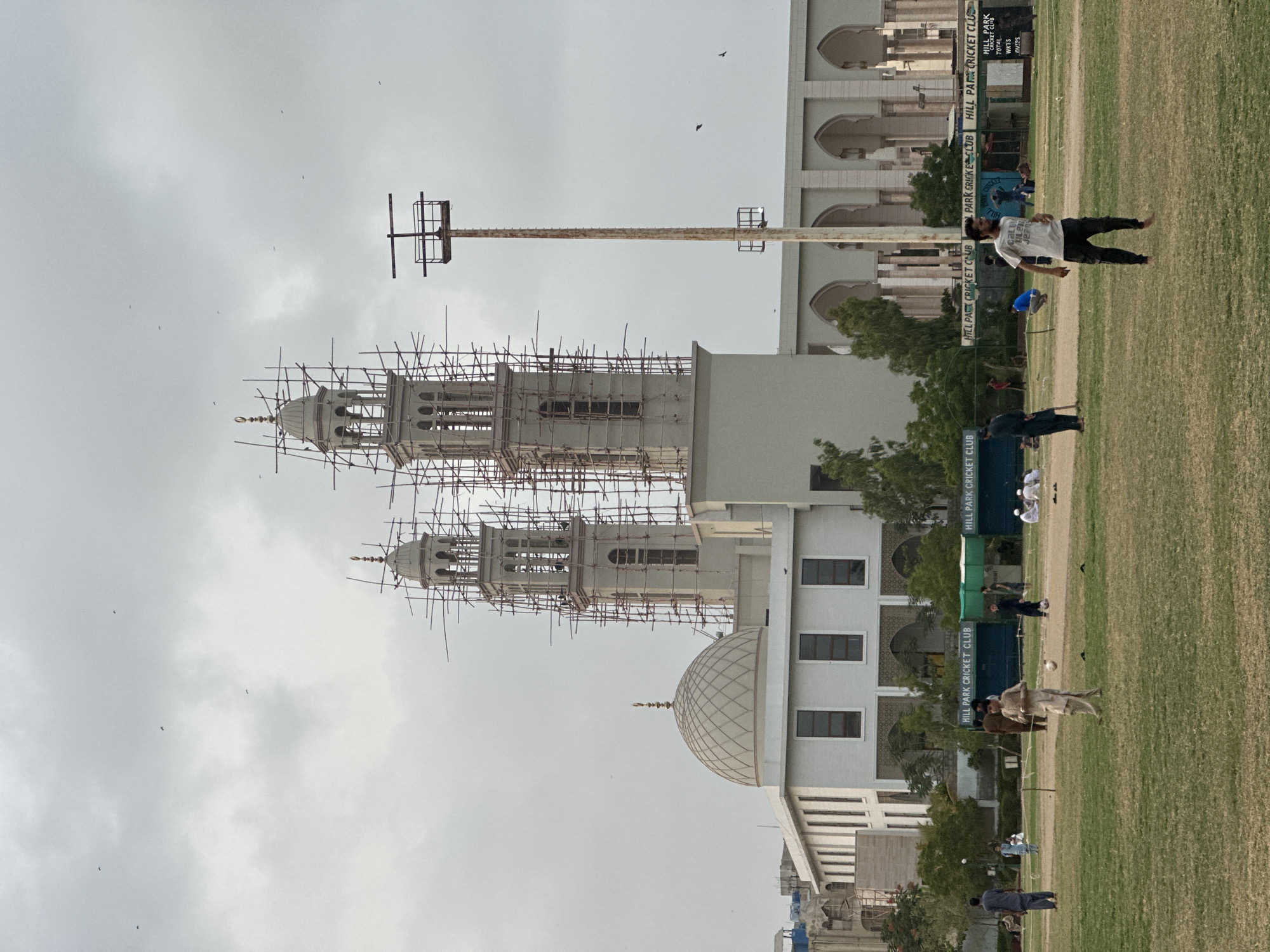 Cricket and construction: Karachi mosque rises behind a park field