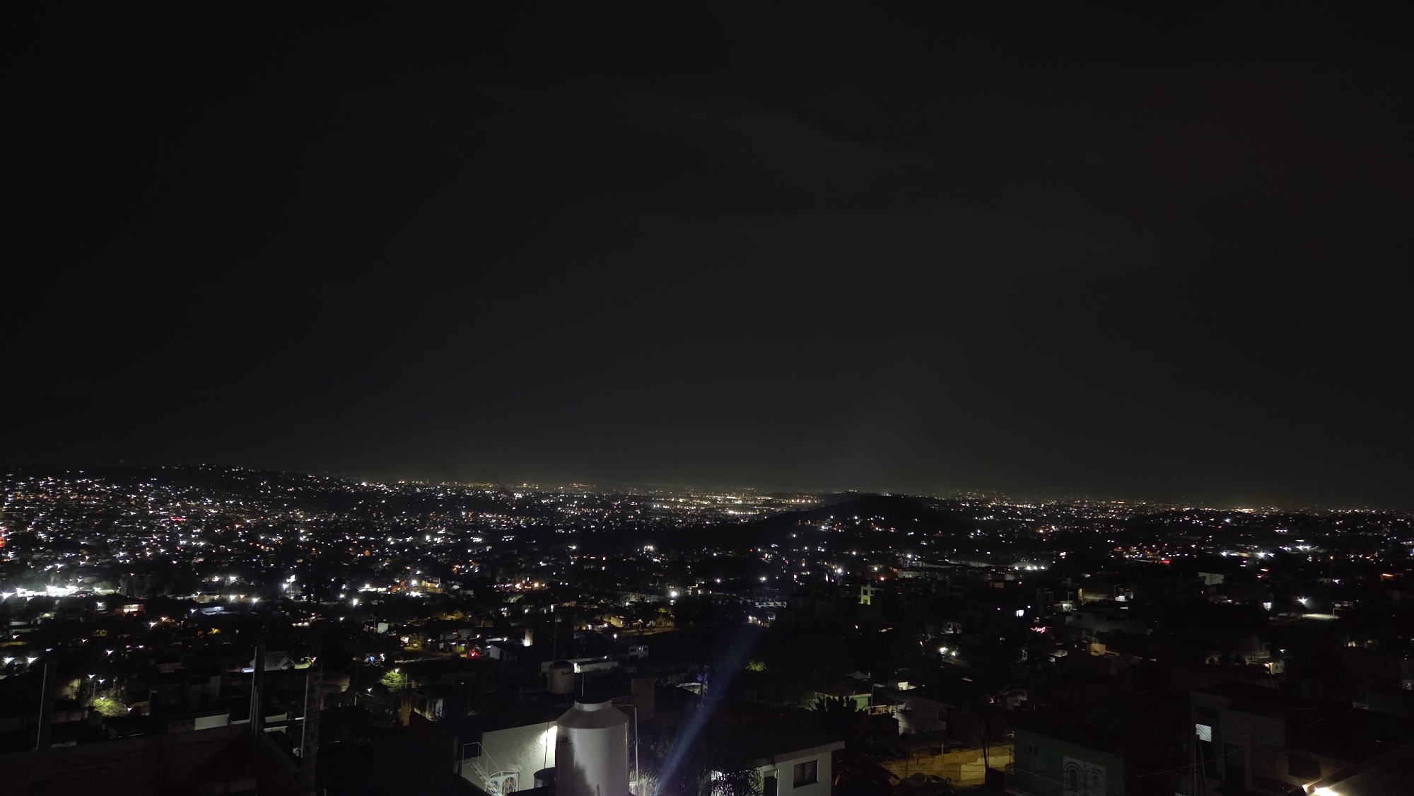 Nighttime cityscape captured in Tonalá, Mexico showing illuminated urban sprawl