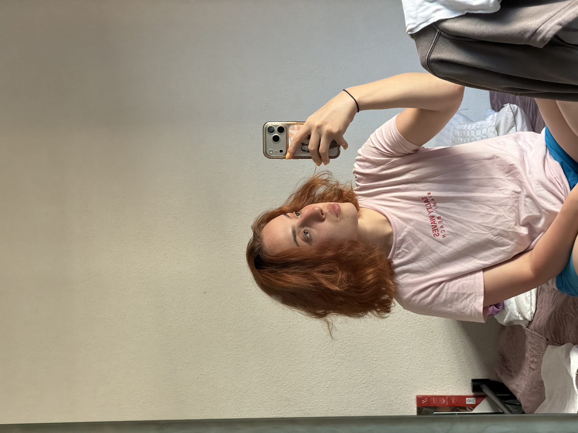 Mirror selfies in a Strasbourg bedroom, pink Miami Beach tee