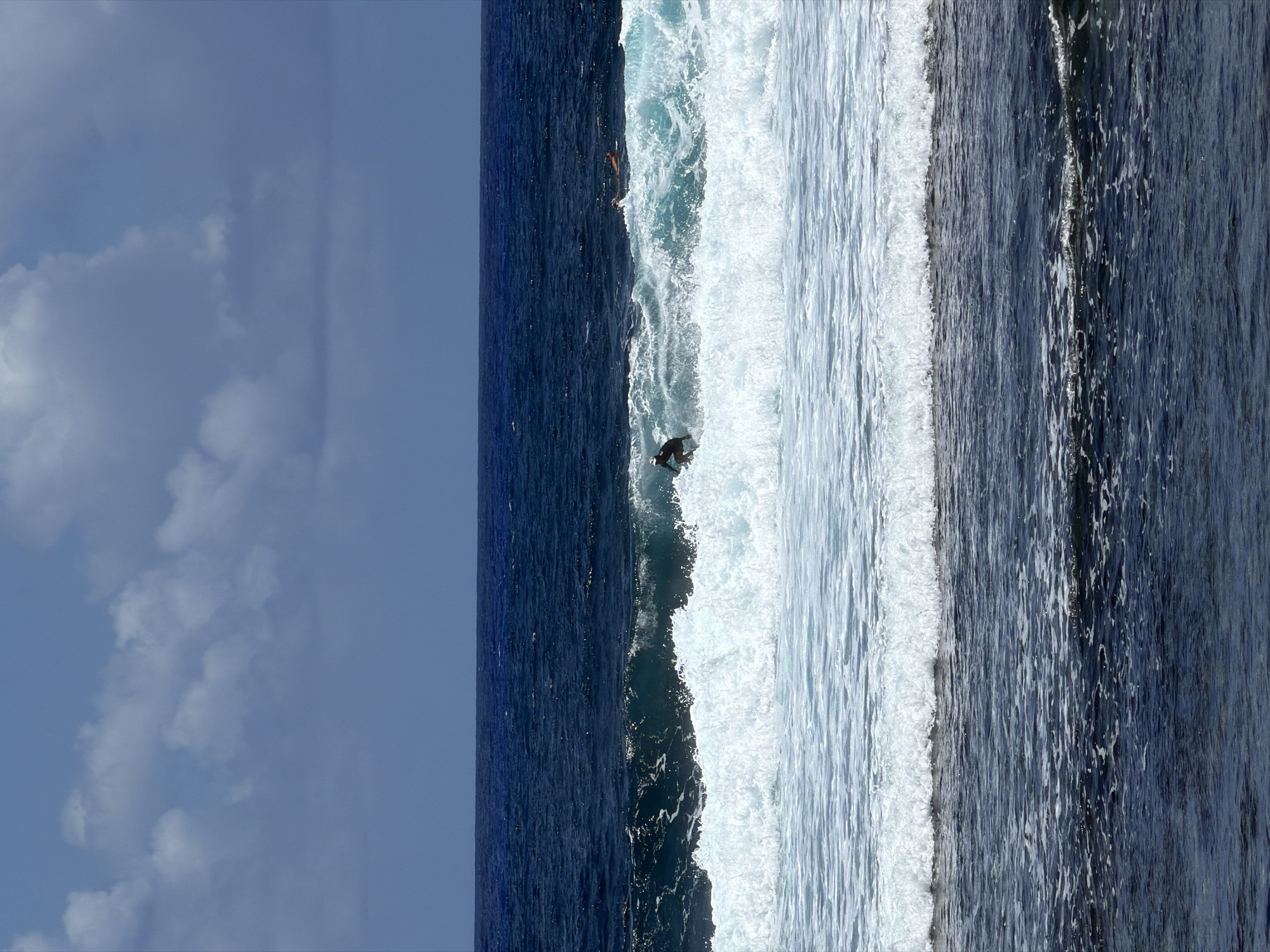 Surfer rides wave under clear skies in General Luna