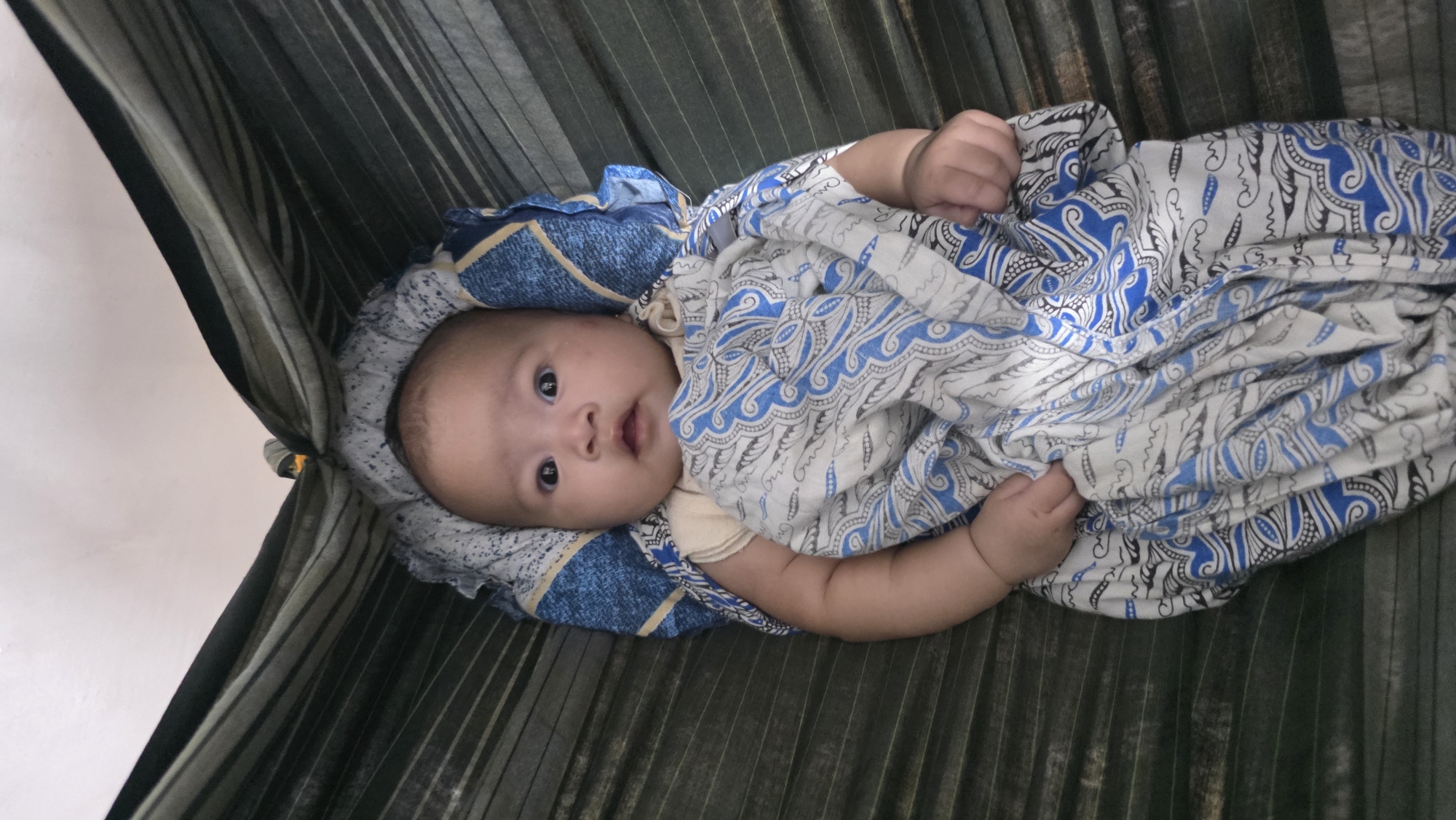 Baby rests peacefully in hammock in Lhokseumawe, Indonesia