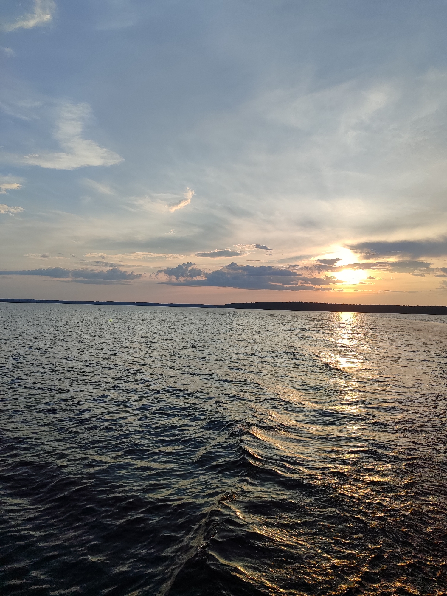 Lake or river at golden hour, treeline on the horizon