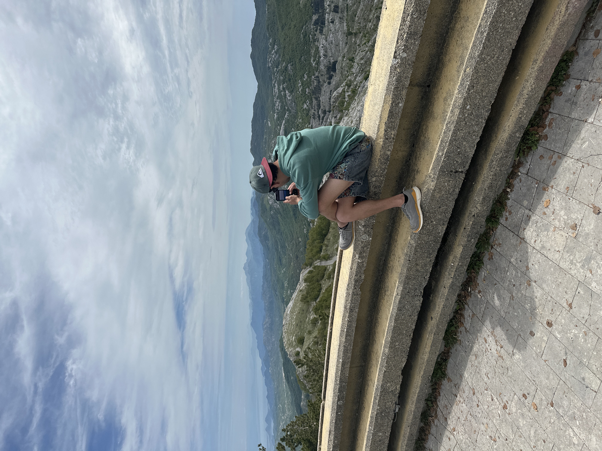 Tourist photographs mountain views at Montenegro's Lovćen National Park