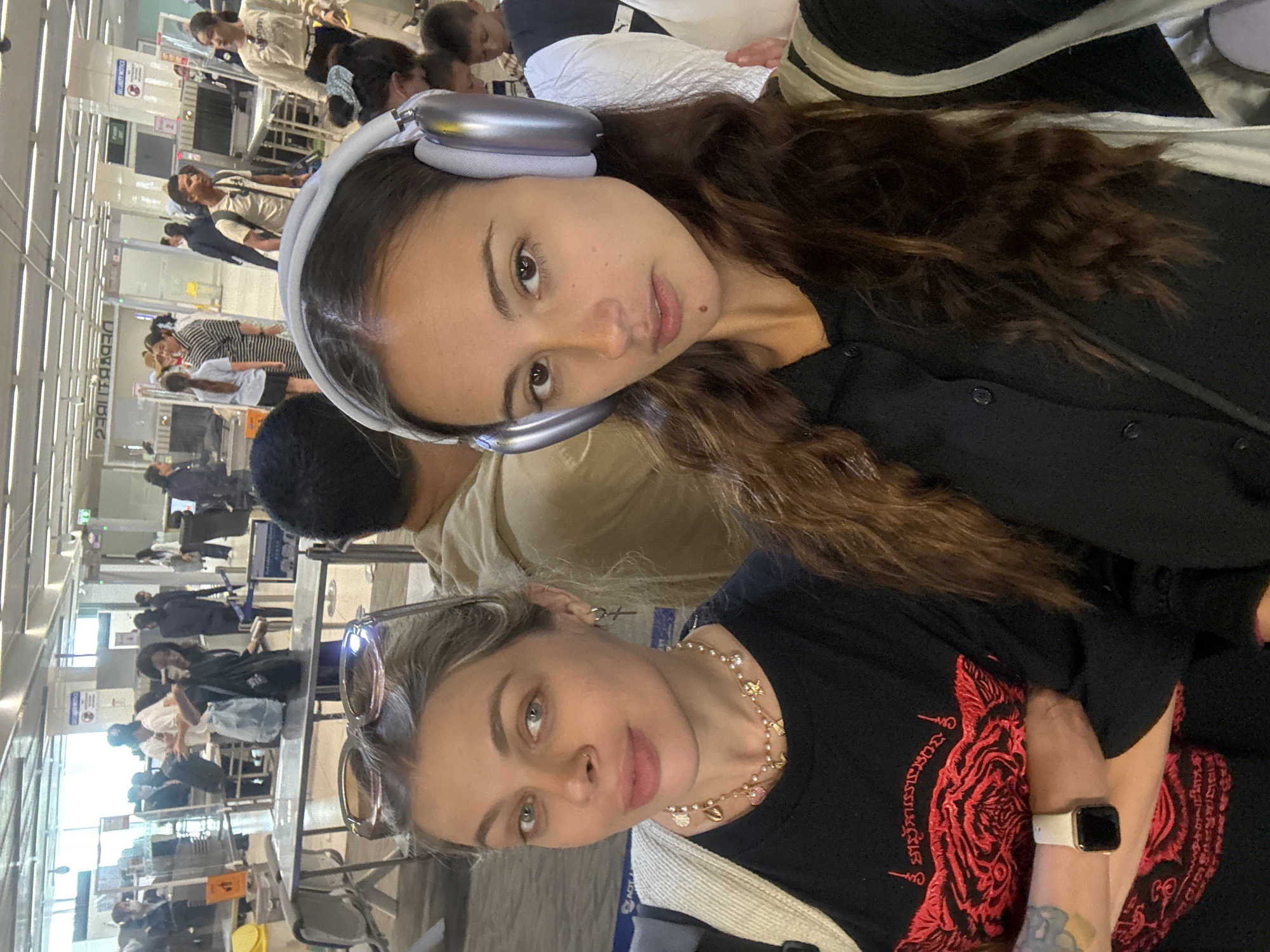 Two women document airport travel experience in Thailand