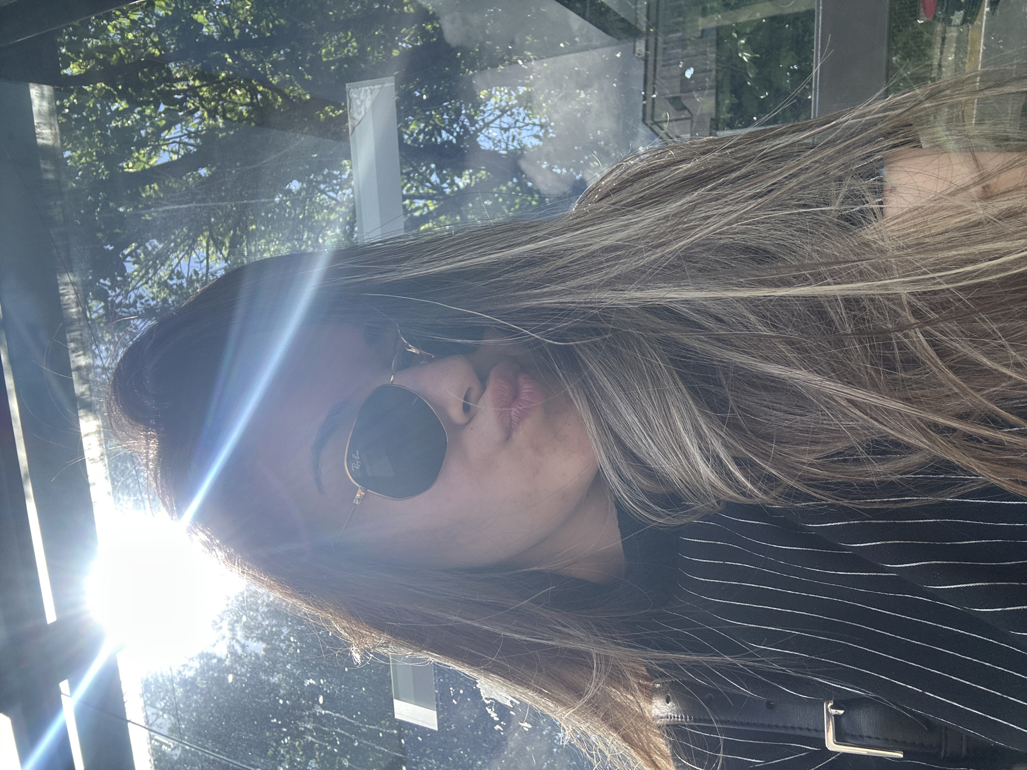 Woman takes playful selfies at Sofia bus stop