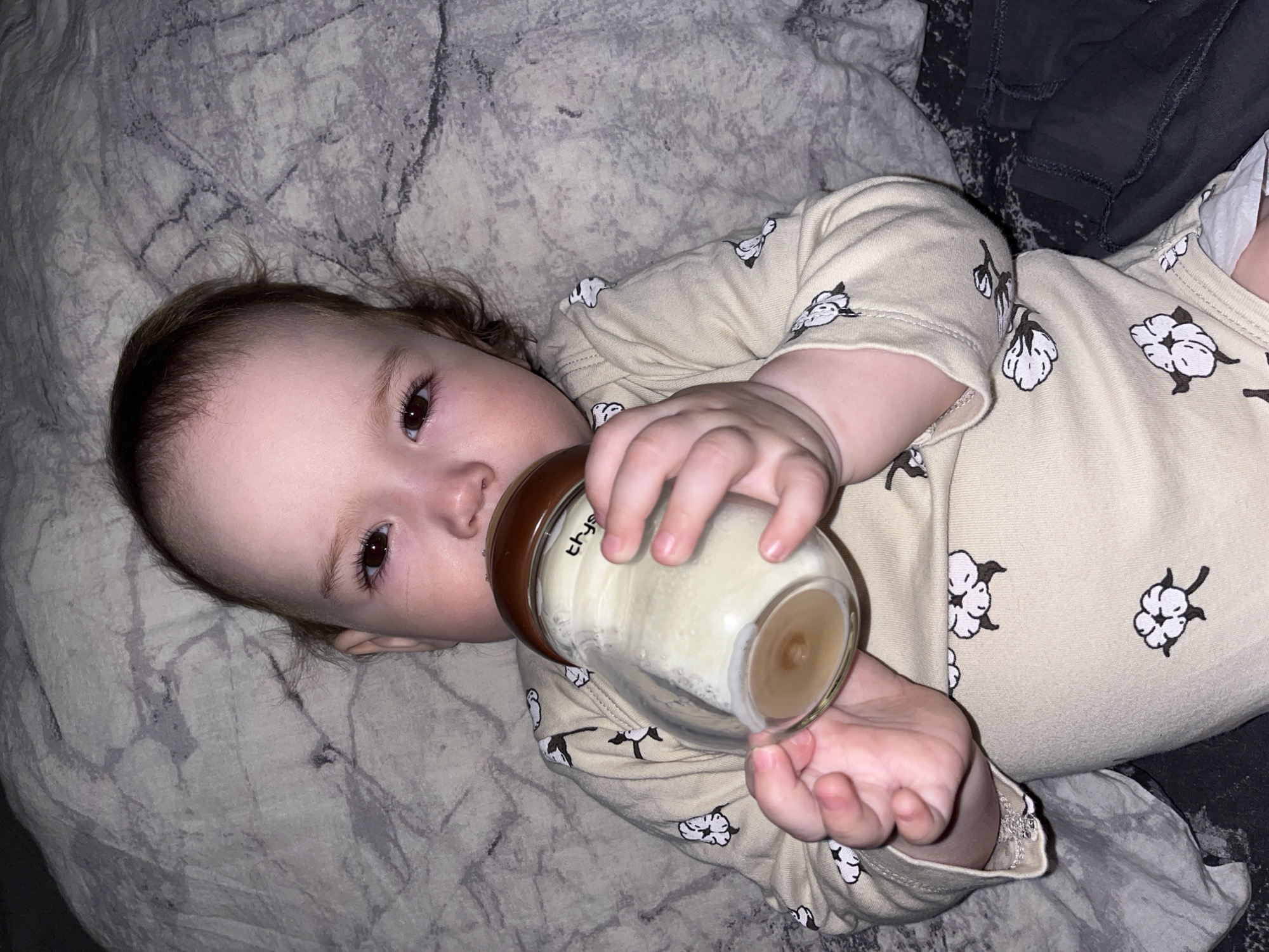 Baby feeds from bottle on patterned blanket in Shushary