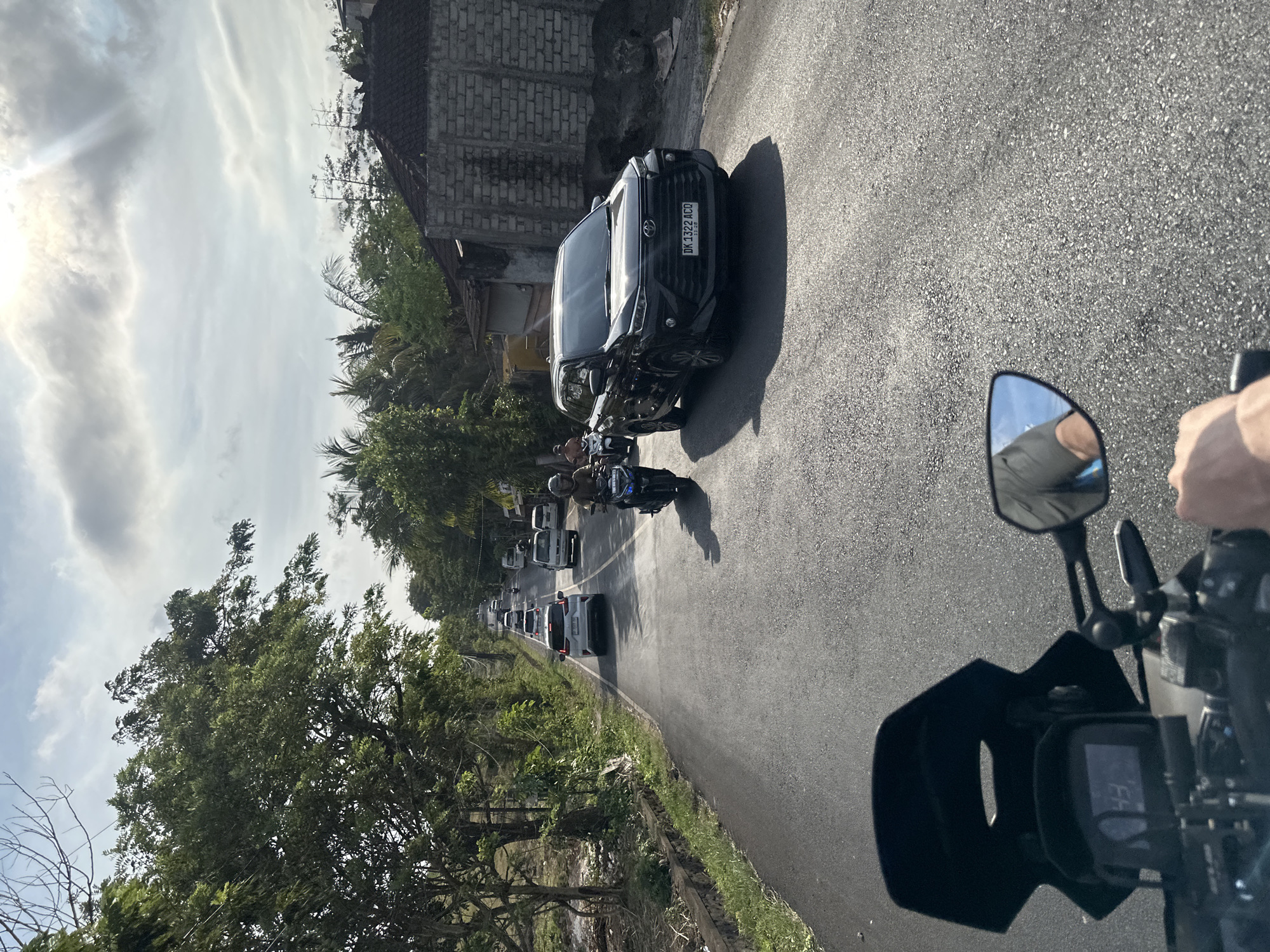 Motorcycle rider observes parked SUV on Kuta Selatan street