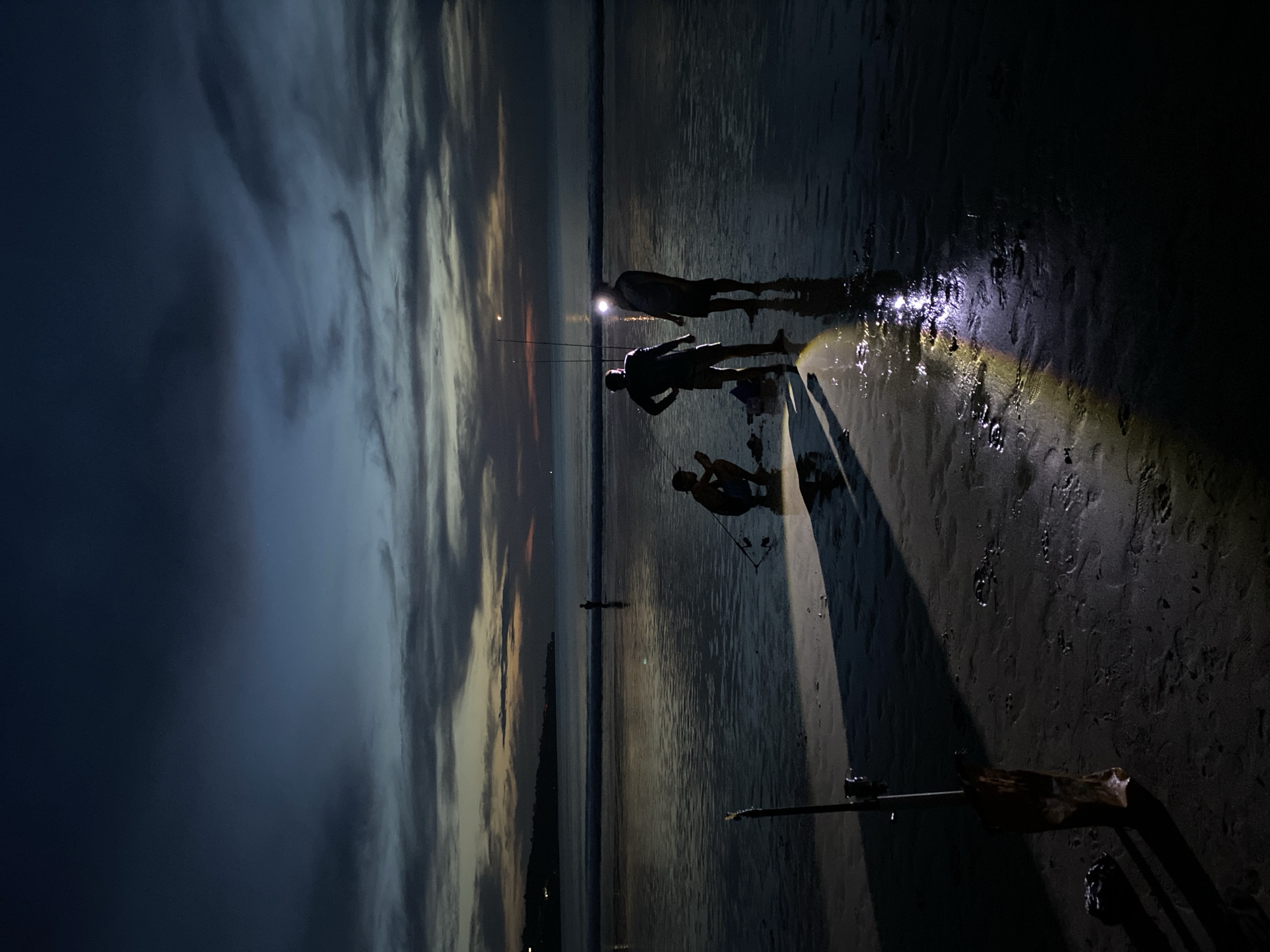 Evening beachgoers gather with flashlight in Kuta Selatan