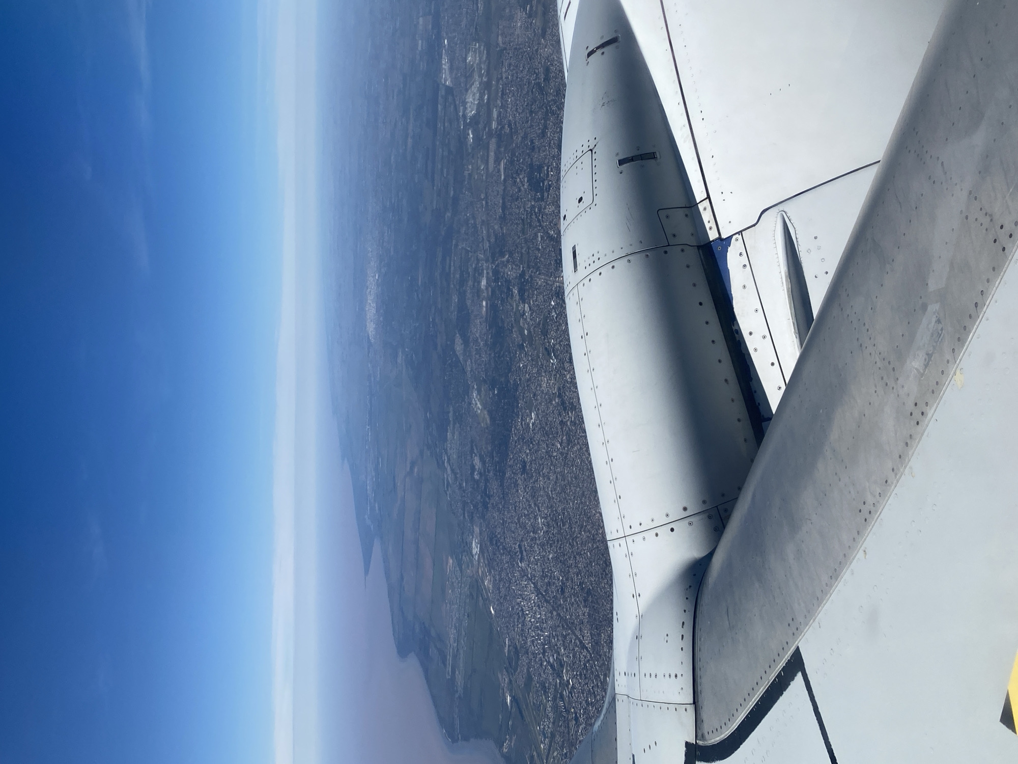 Aircraft passenger views Monte Chingolo cityscape from airplane window