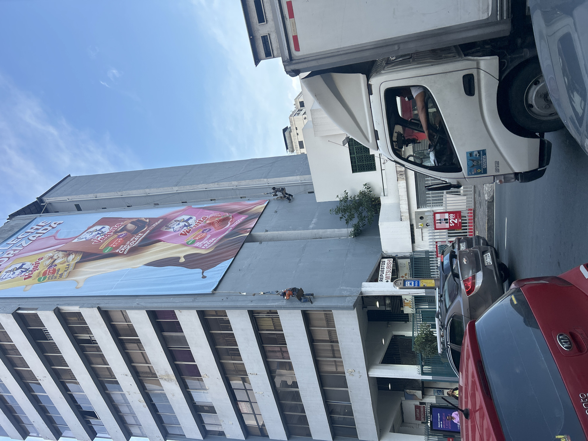 Workers Install Vaquiita Milk Advertisement in Guayaquil