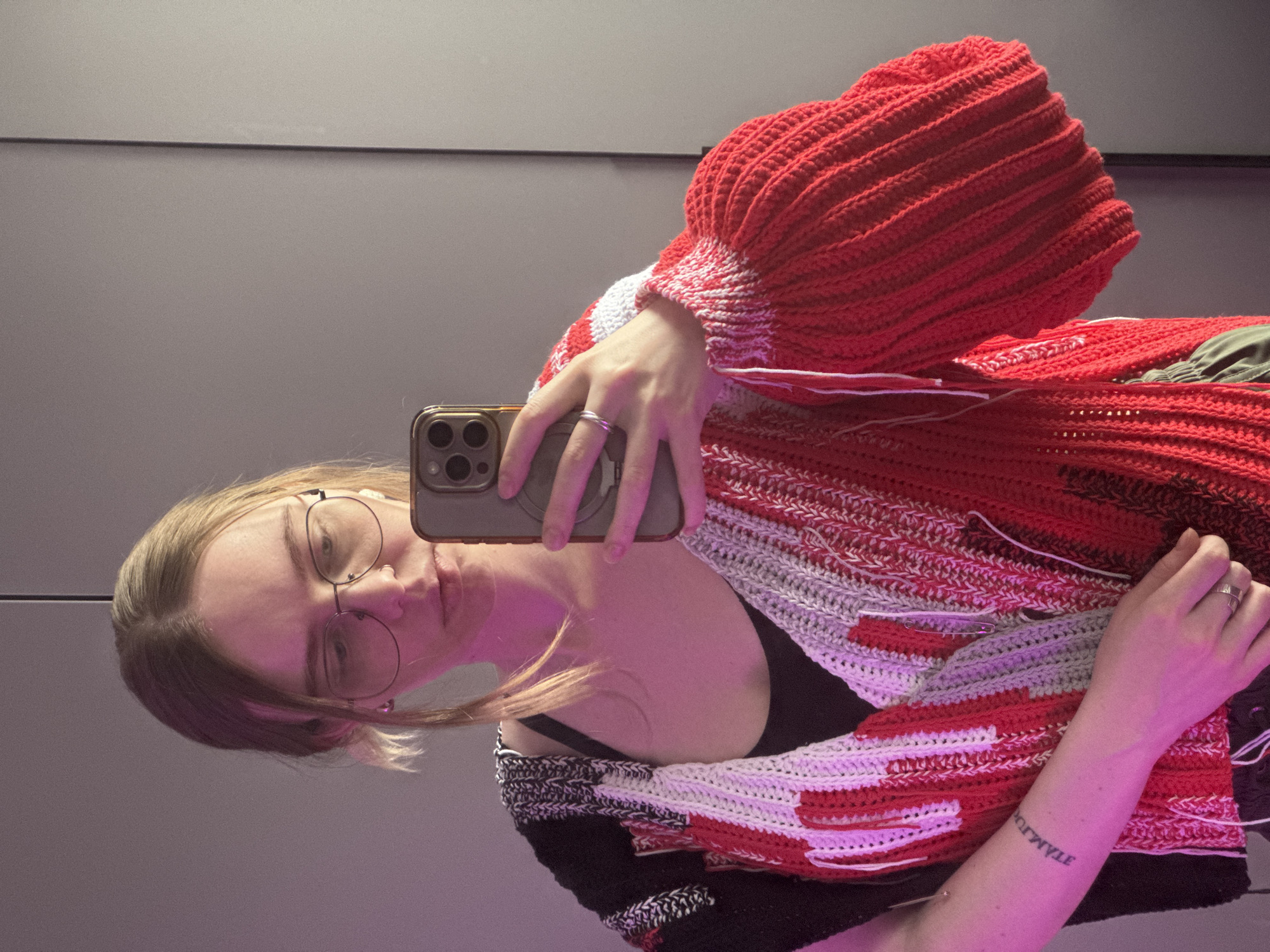 Woman documents trying on crocheted sweater in Krasnoyarsk morning