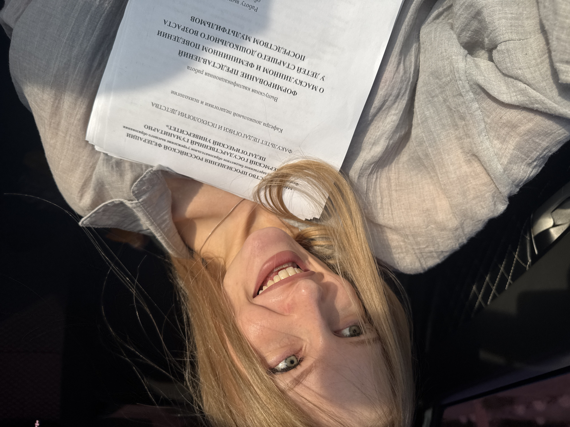 Smiling with a stack of printed documents in Perm