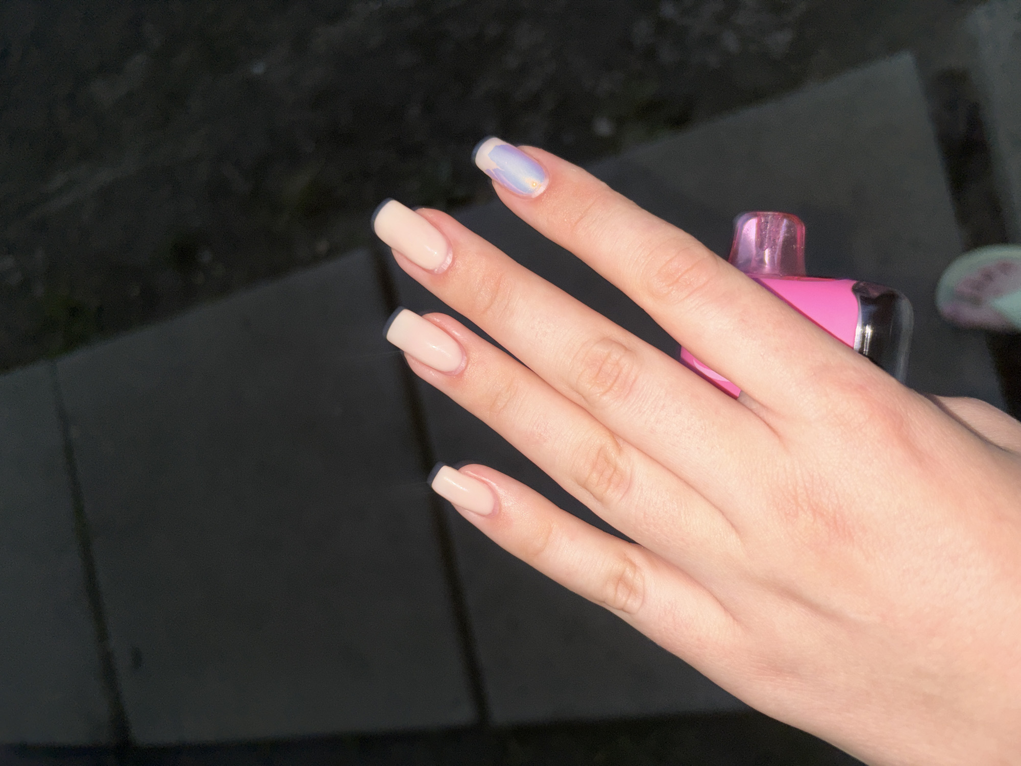 Graffiti-covered restroom stop with a vape and fresh manicure