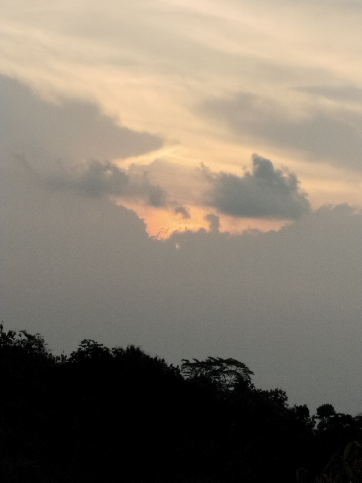 Cloudy sunset documented in Menjing, Indonesia with silhouetted trees