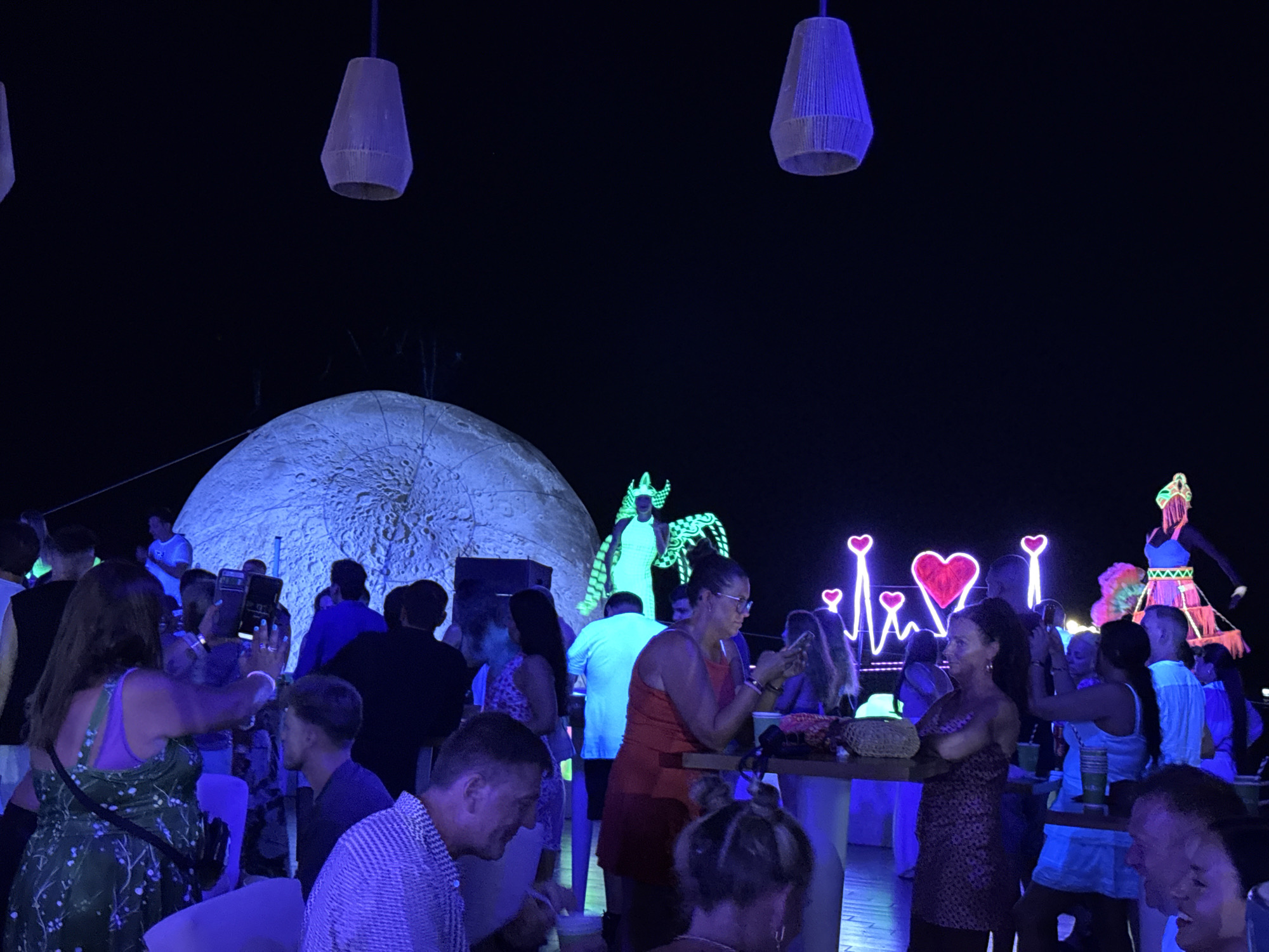 Neon-lit outdoor party with costumed performer and fireworks in Egypt