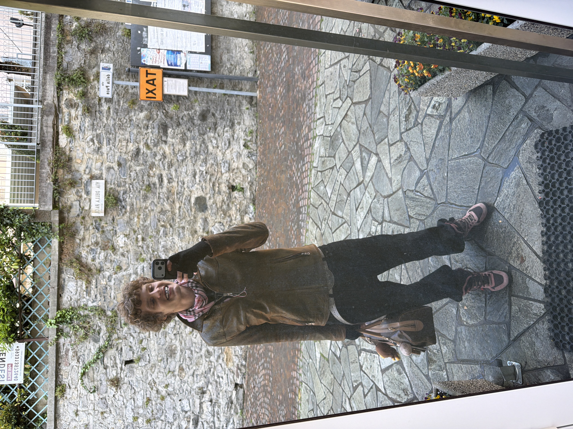 Tourist takes selfies on mountain balcony in Gittana, Italy