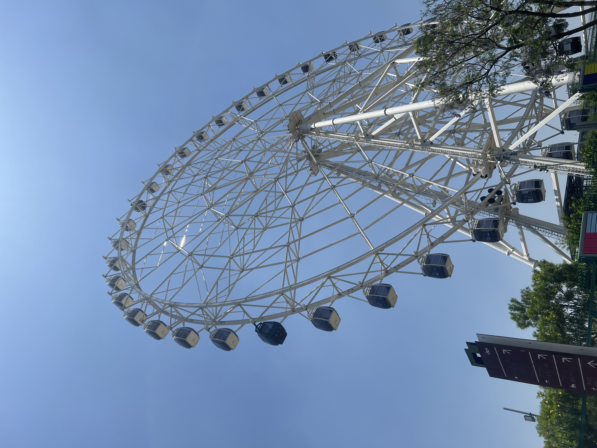 White Ferris wheel observed against blue sky in Mexico City
