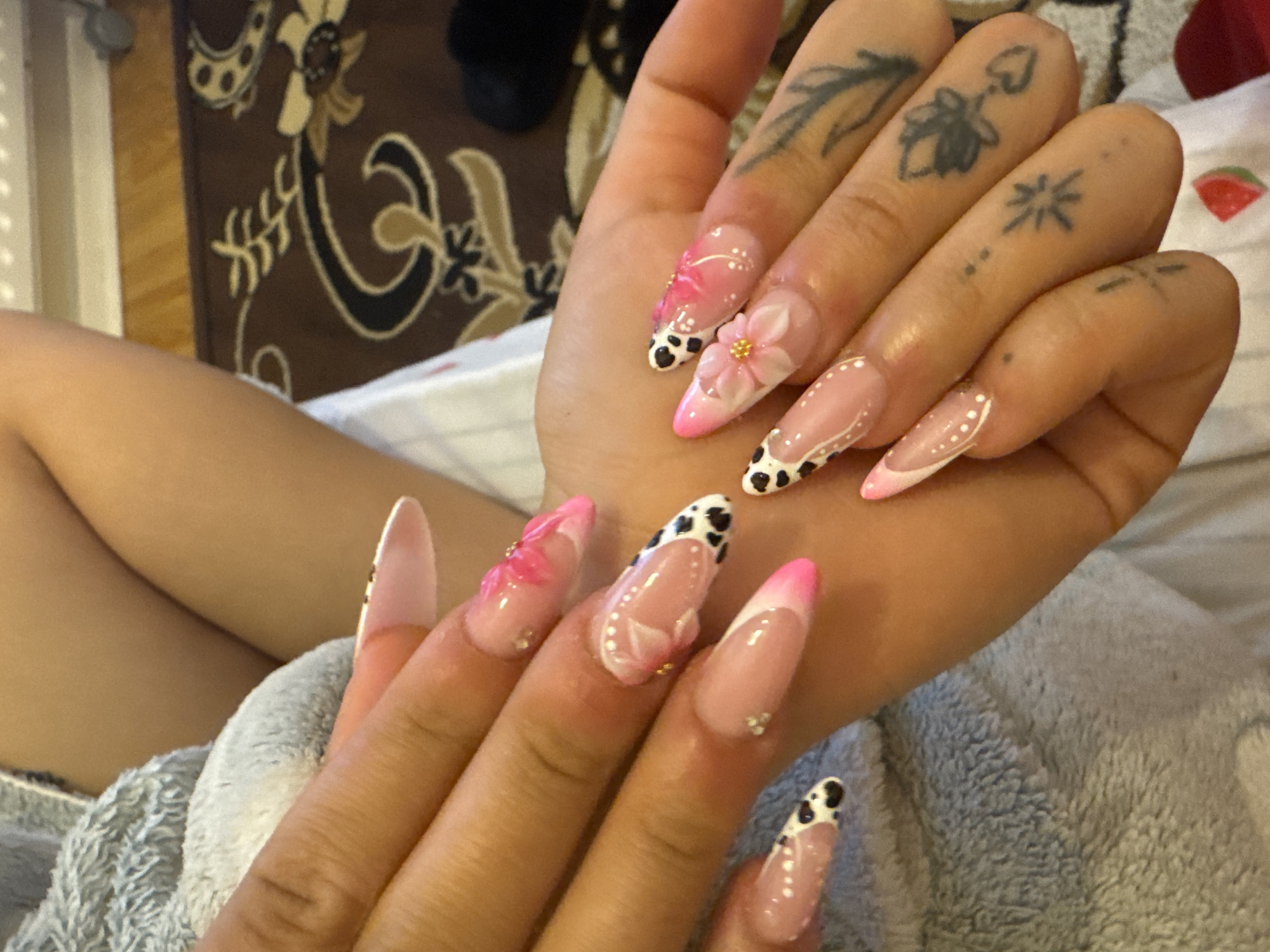 Detailed acrylic nail art with pink French tips and 3D accents