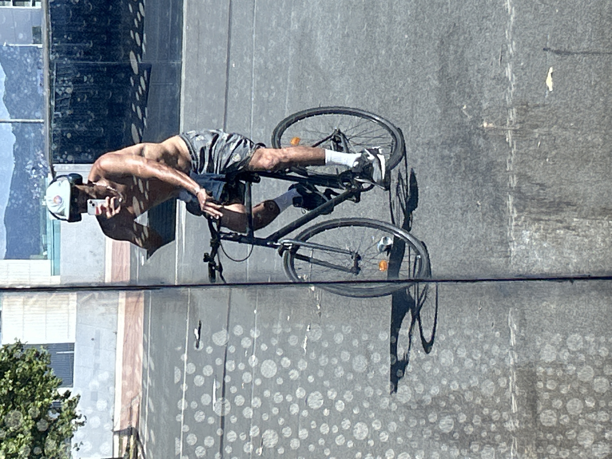 Cyclist rides through Barcelona while using smartphone and wearing headphones