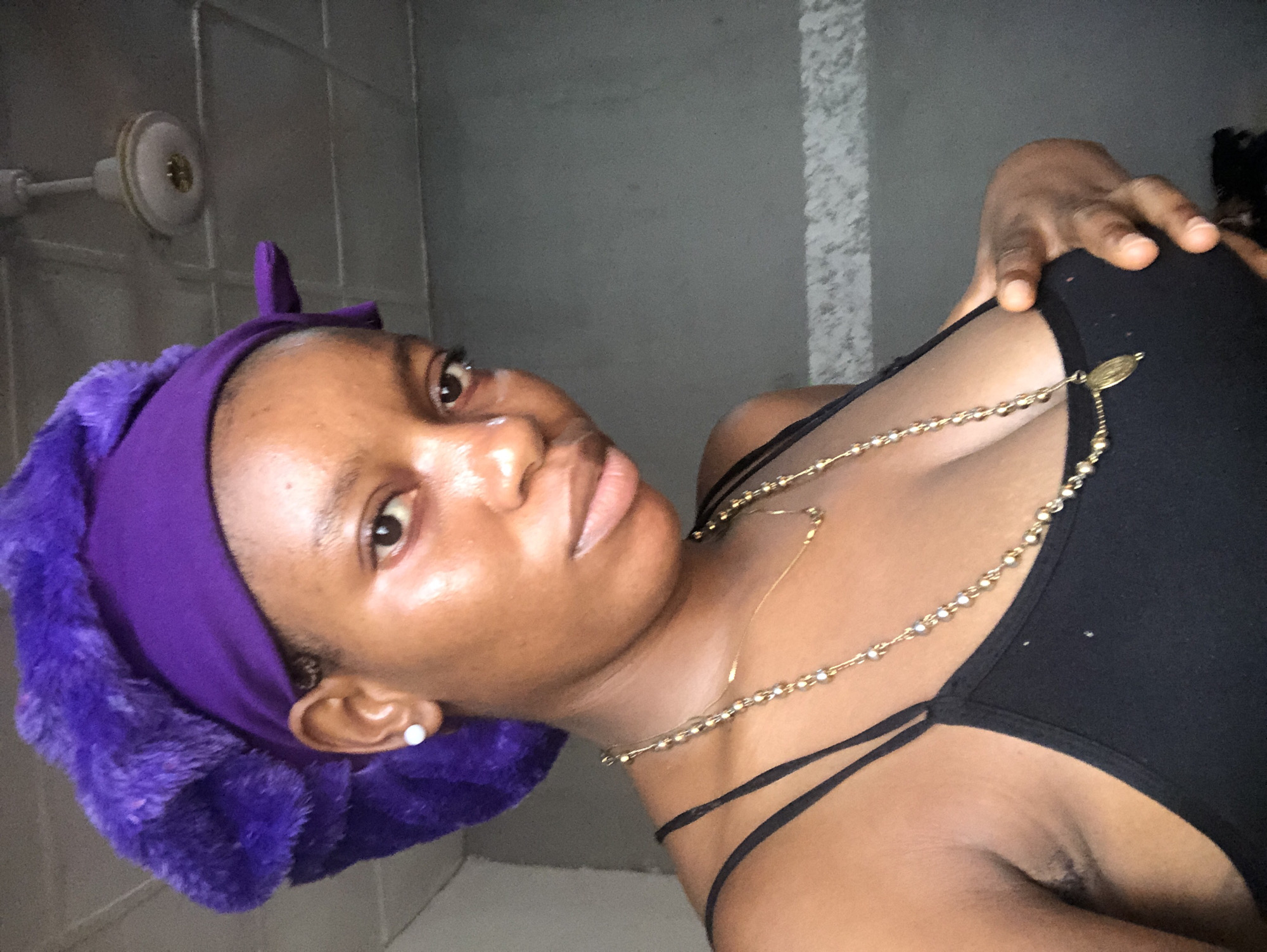 Woman in purple headwrap photographed indoors in Nigeria
