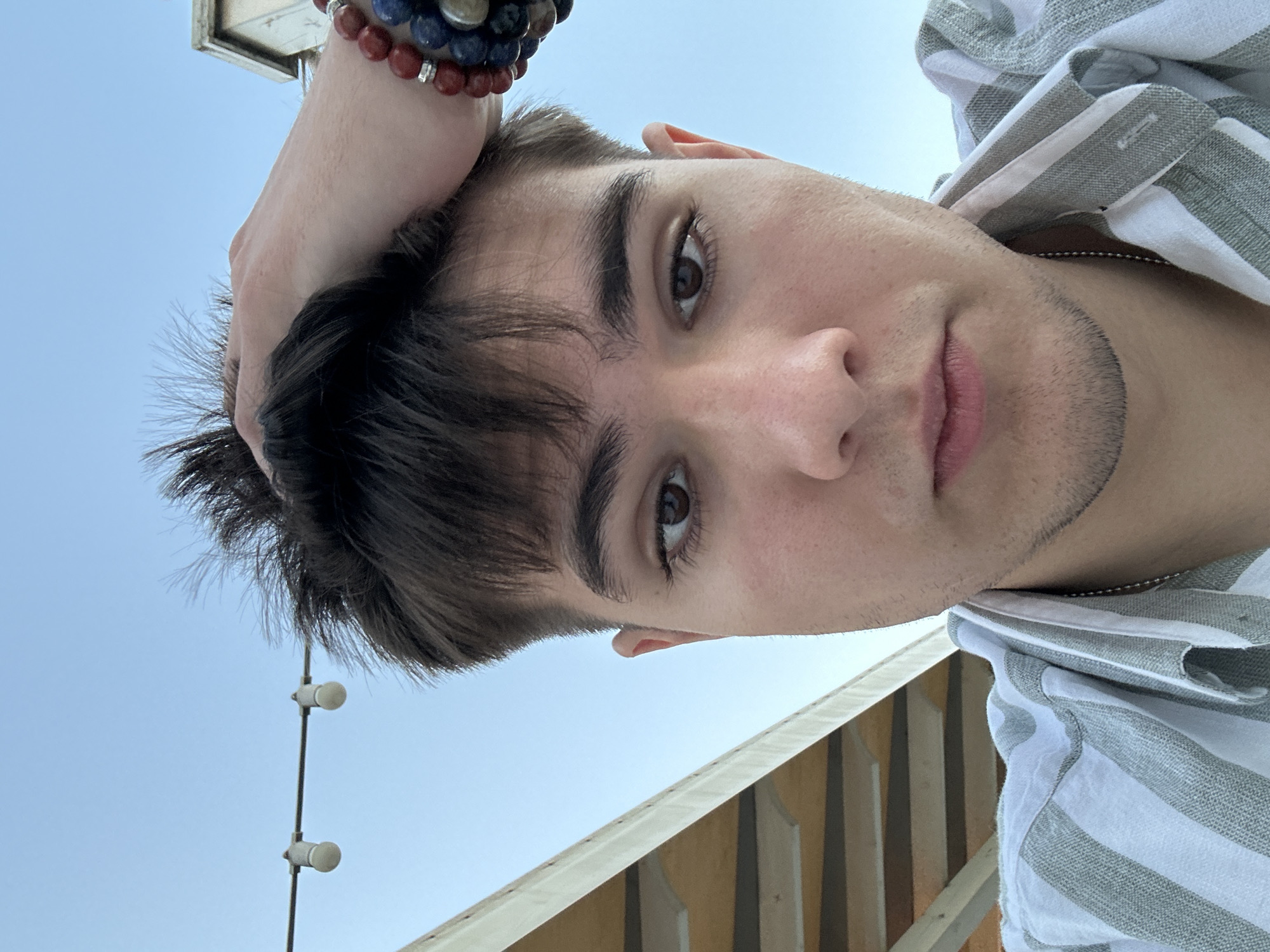 Low-angle selfie in Odesa featuring a colorful beaded bracelet