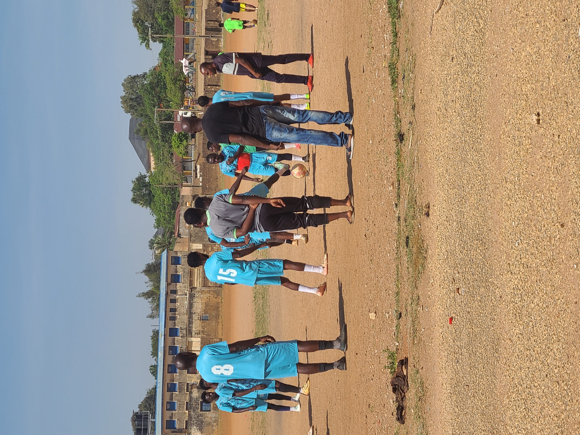 Soccer team holds training session on dirt field