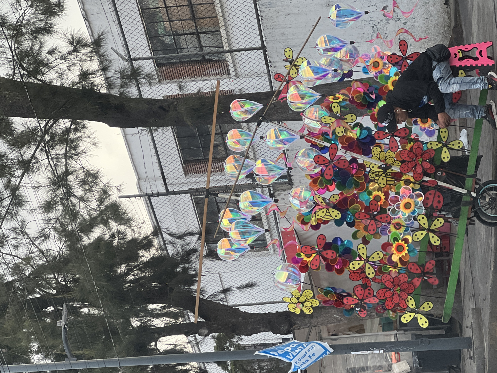 Street vendor sells colorful pinwheels from cart in Mexico City