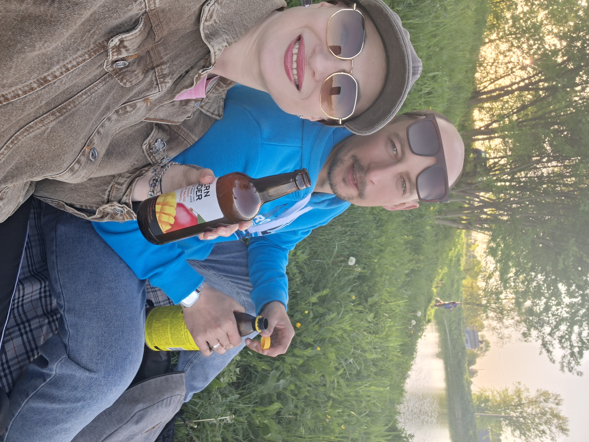 Couple enjoys afternoon picnic by Belarus waterway with drinks