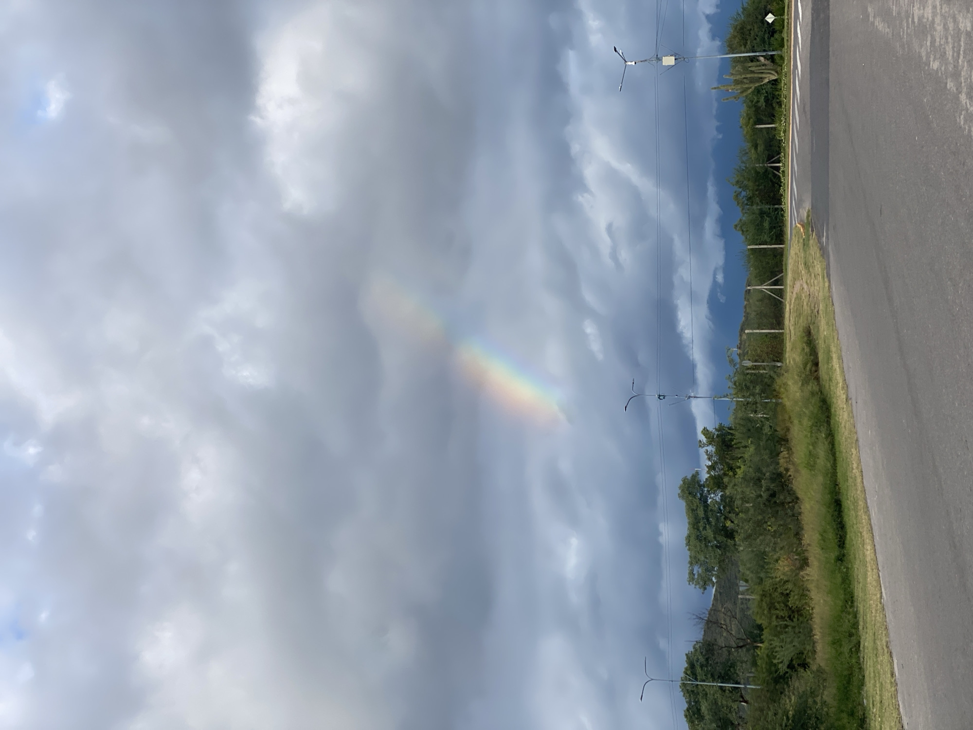 Rainbow appears over Catamarca roadway during evening hours