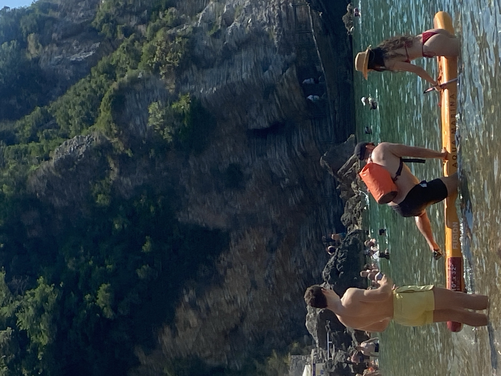 Paddleboards and pedal boats off Budva's rocky shore