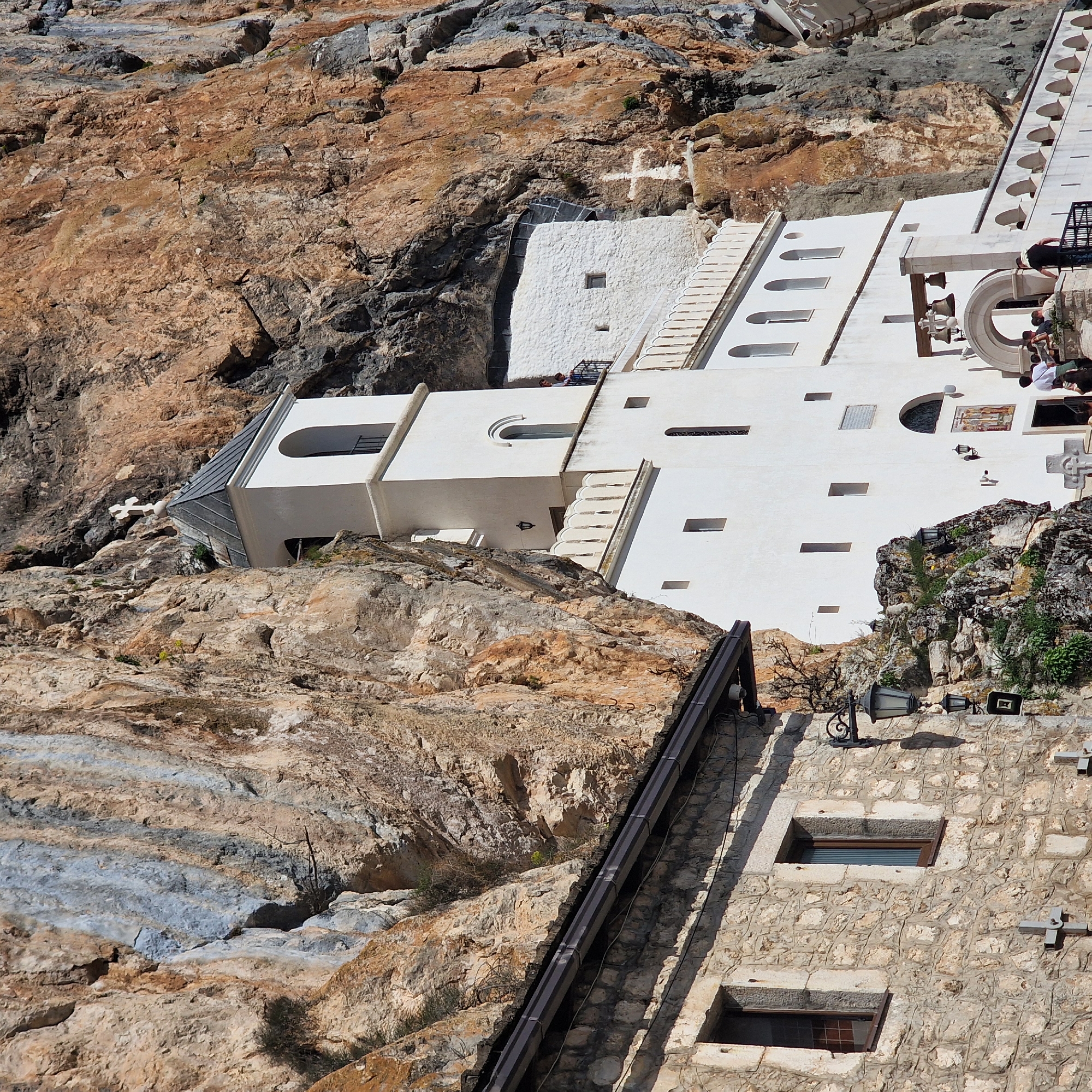Pilgrims queue at cliff-built Ostrog Monastery in Montenegro