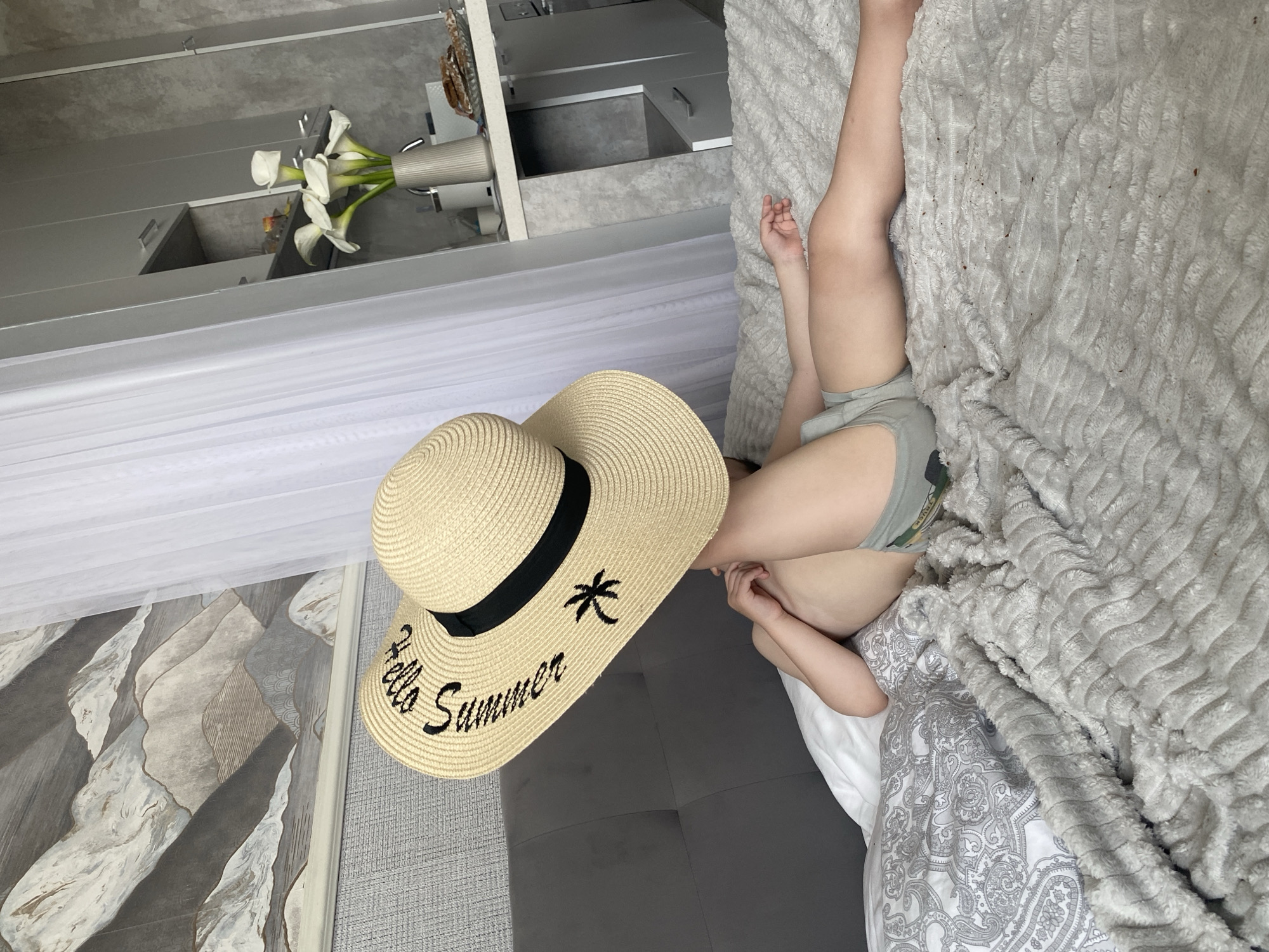Toddler enjoys summer hat and apple during morning playtime