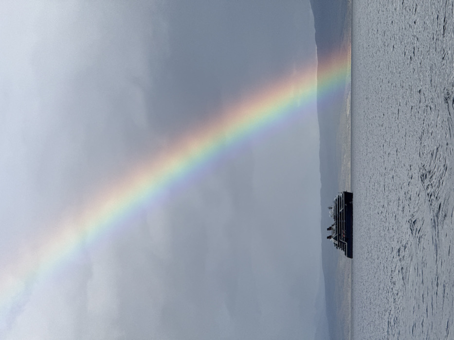 Cruise ship sails Beagle Channel amid rainbow near Ushuaia