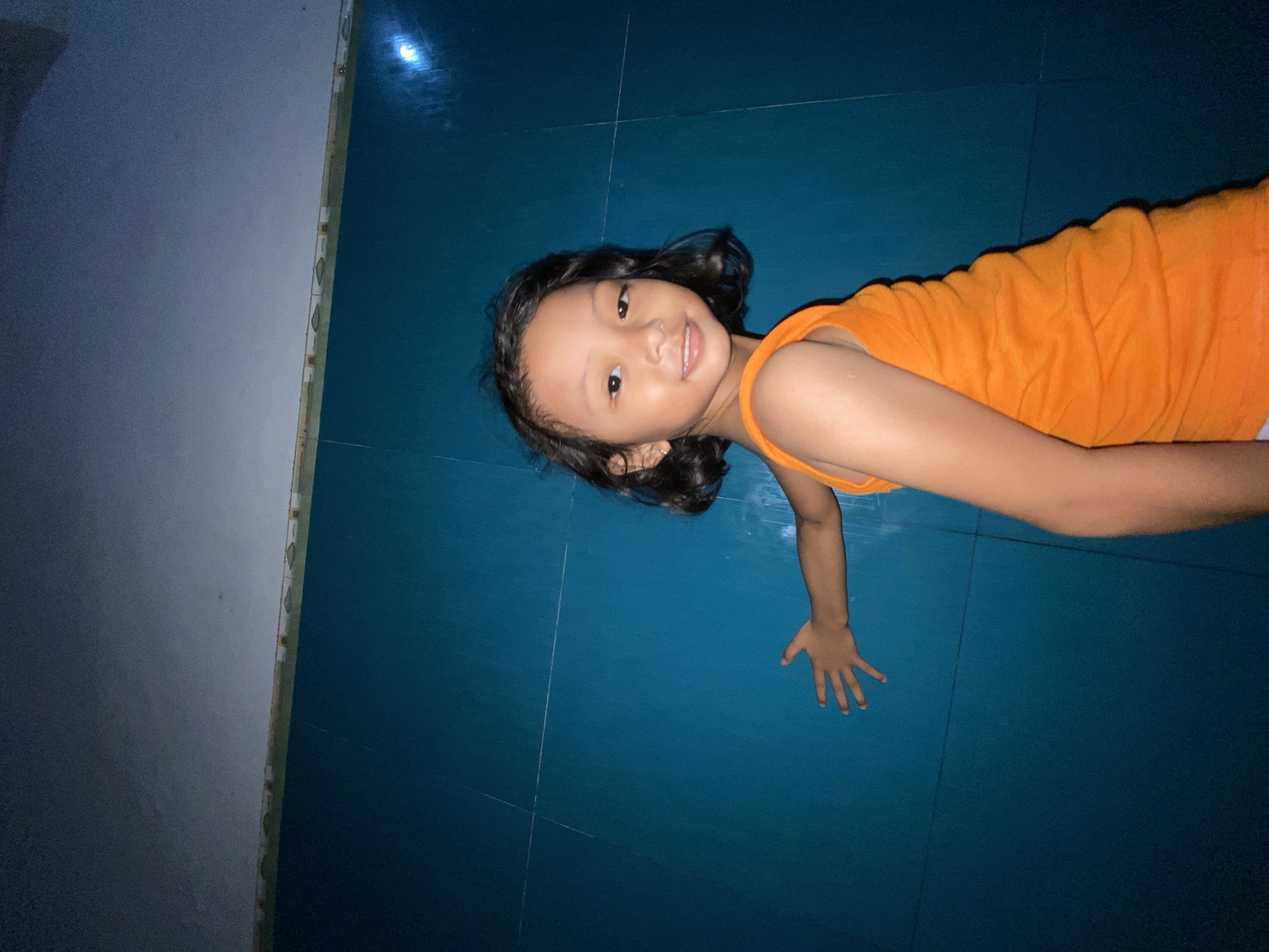 Child photographed on tiled floor in Gelam, Indonesia