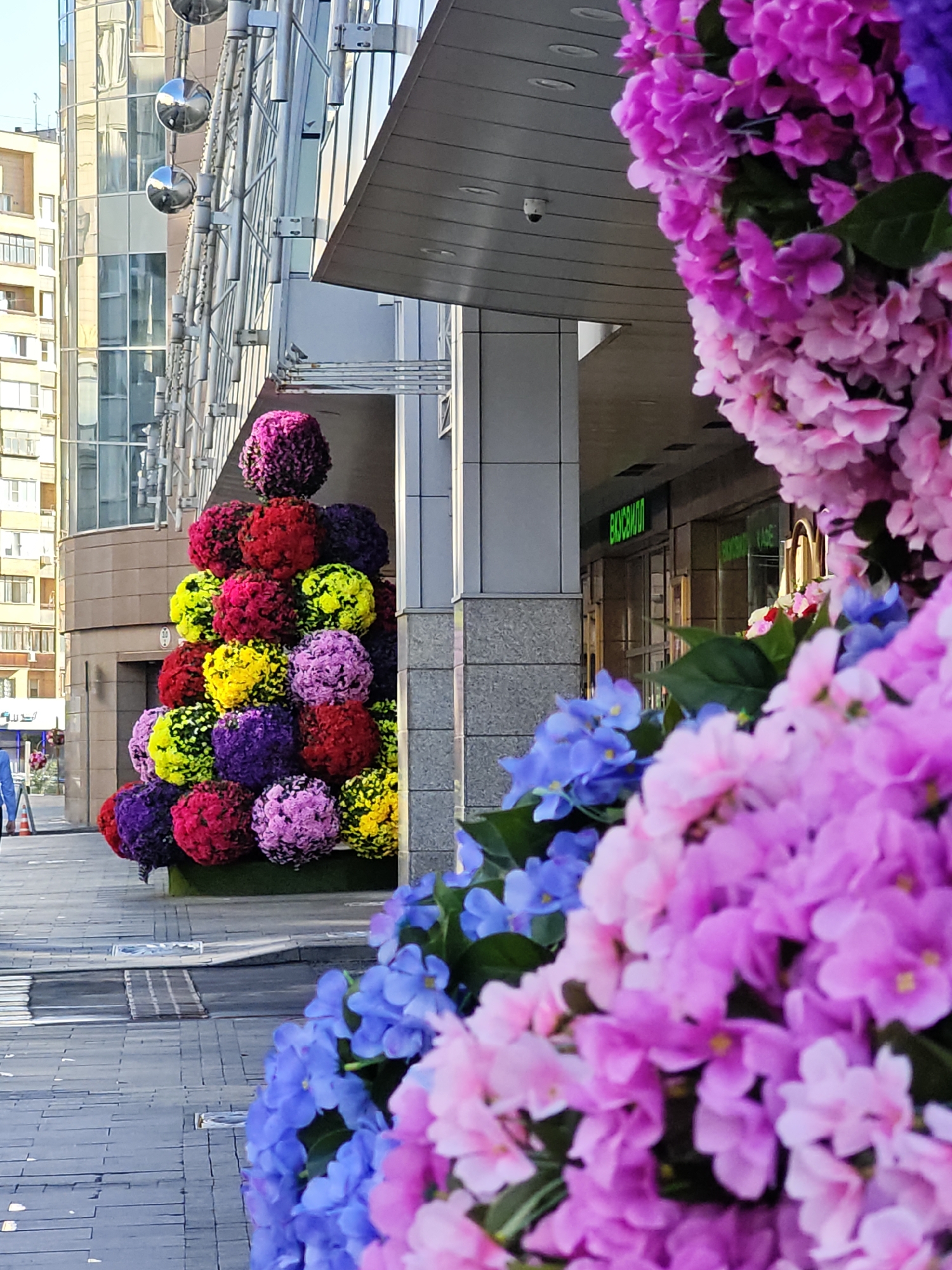 Moscow street dressed up with large floral installations and colorful storefronts