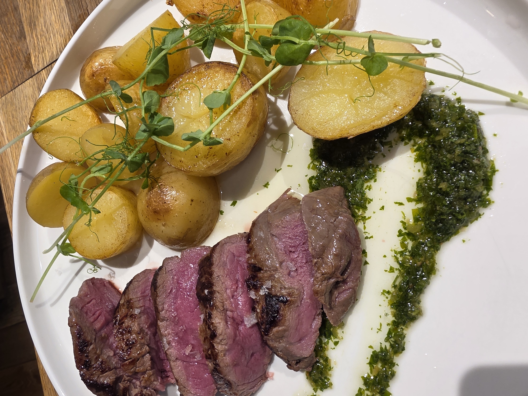 Steak lunch and cocktails on a wooden table