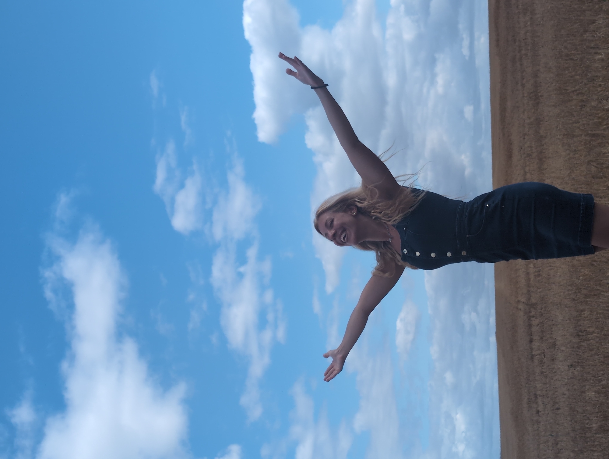 Arms wide open in a golden French countryside field
