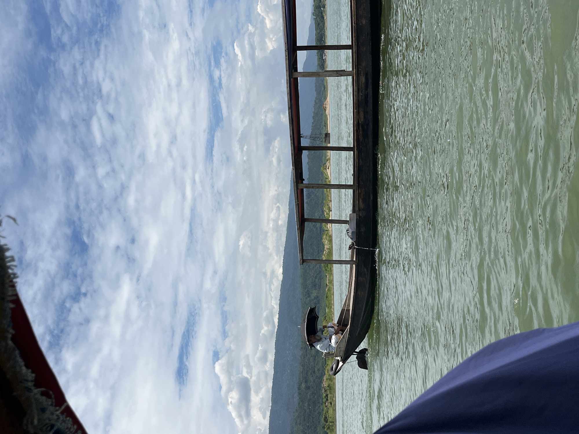 Boat ride along a green river through hilly northeast India