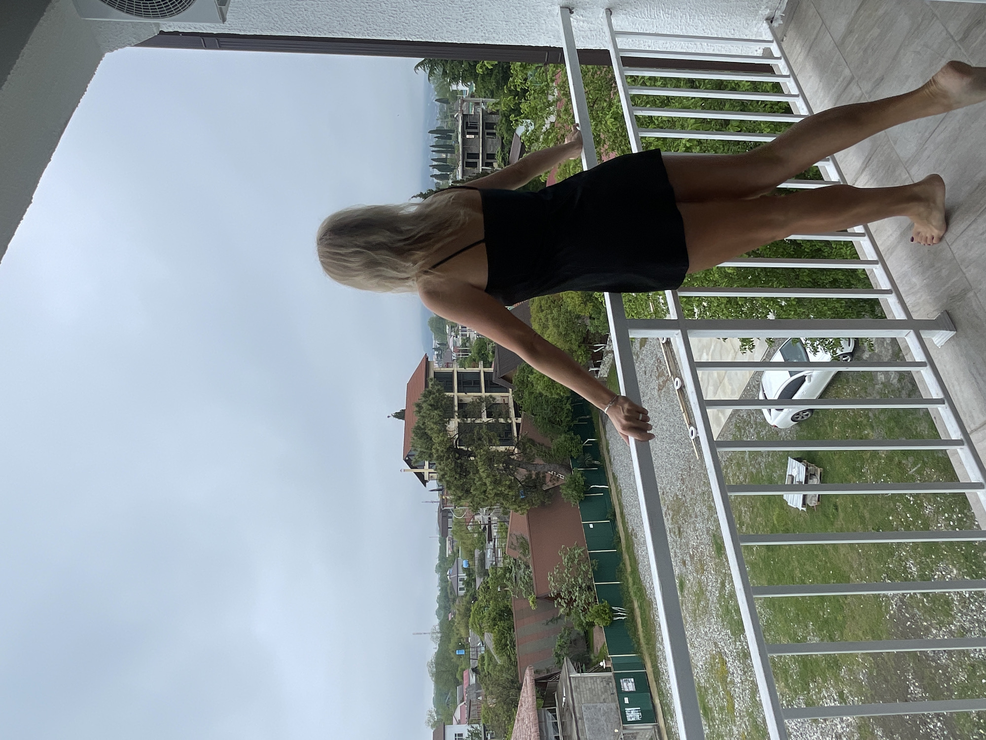 Woman opens curtains, stands at balcony in Giachrypsh morning